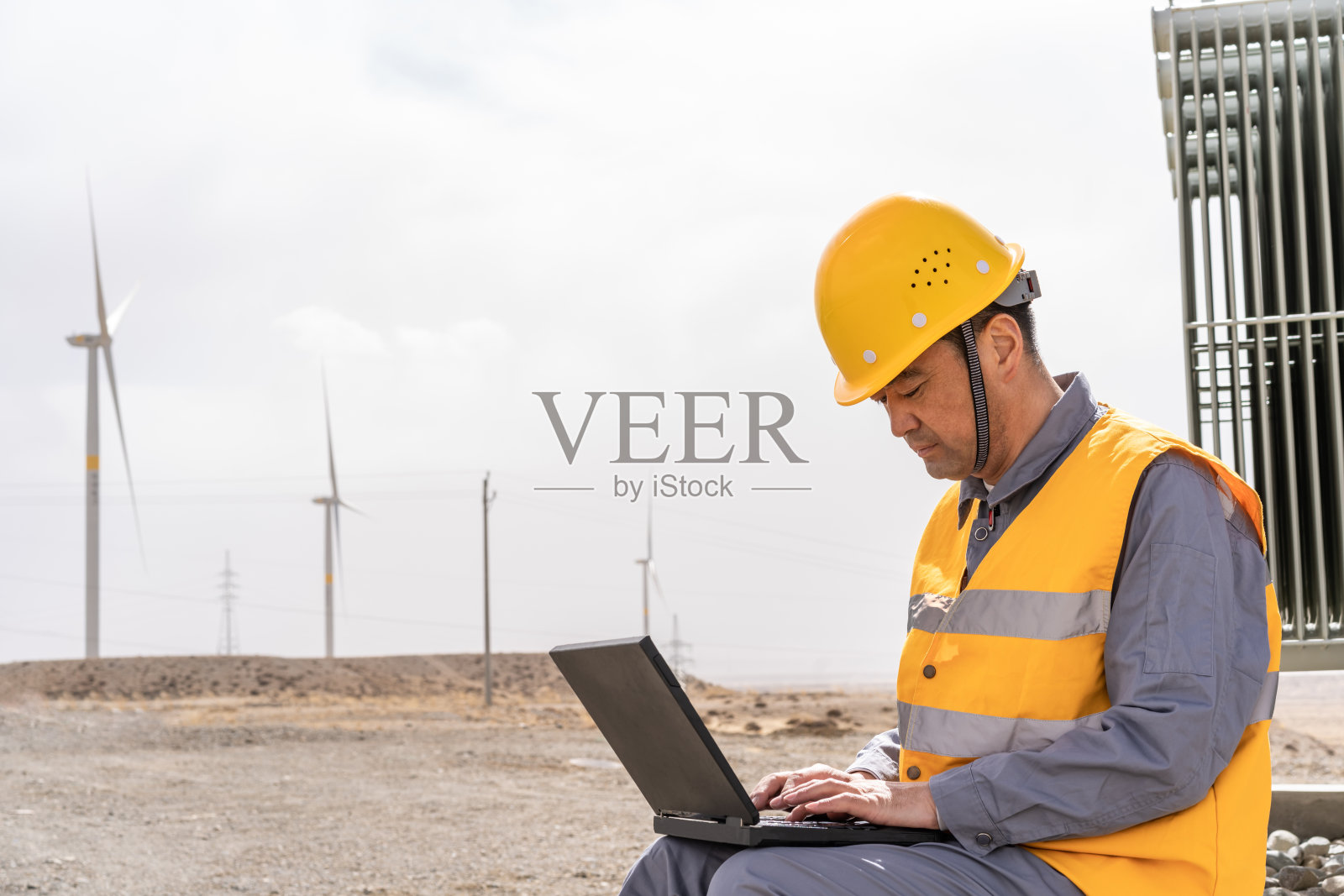 亚洲男性电力工程师在风力发电站工作照片摄影图片