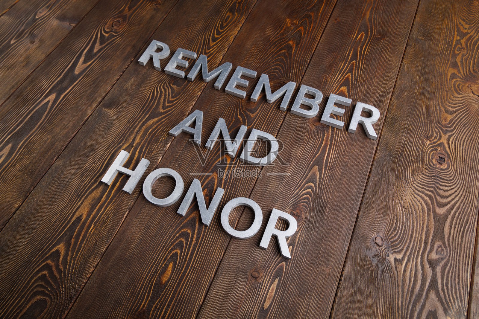 在木制的背景上，银色金属字母将“记住”和“荣誉”放在一起照片摄影图片
