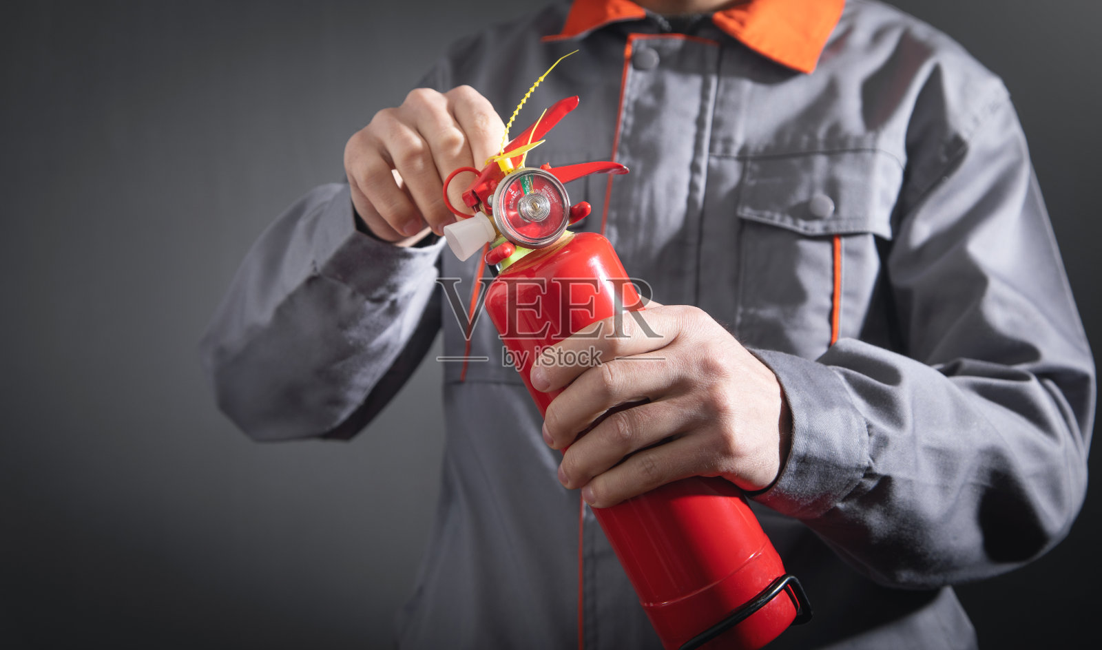 拿着灭火器的白人消防员。照片摄影图片