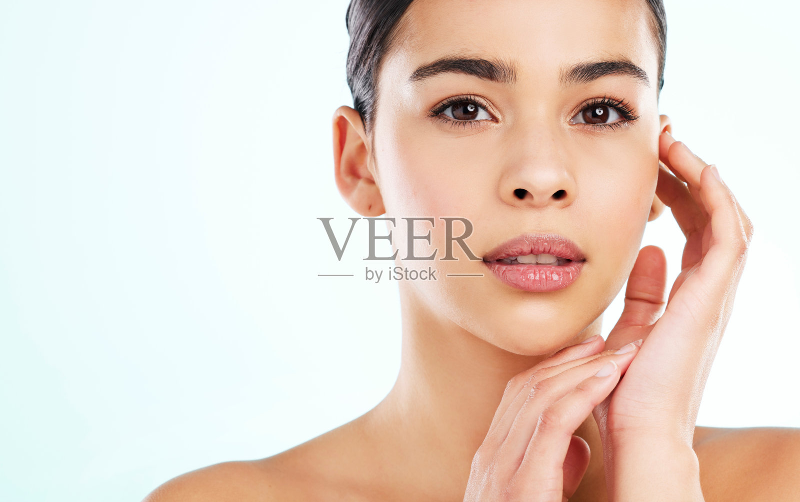 一个有吸引力的年轻女子在灯光背景下摆姿势的工作室肖像照片摄影图片