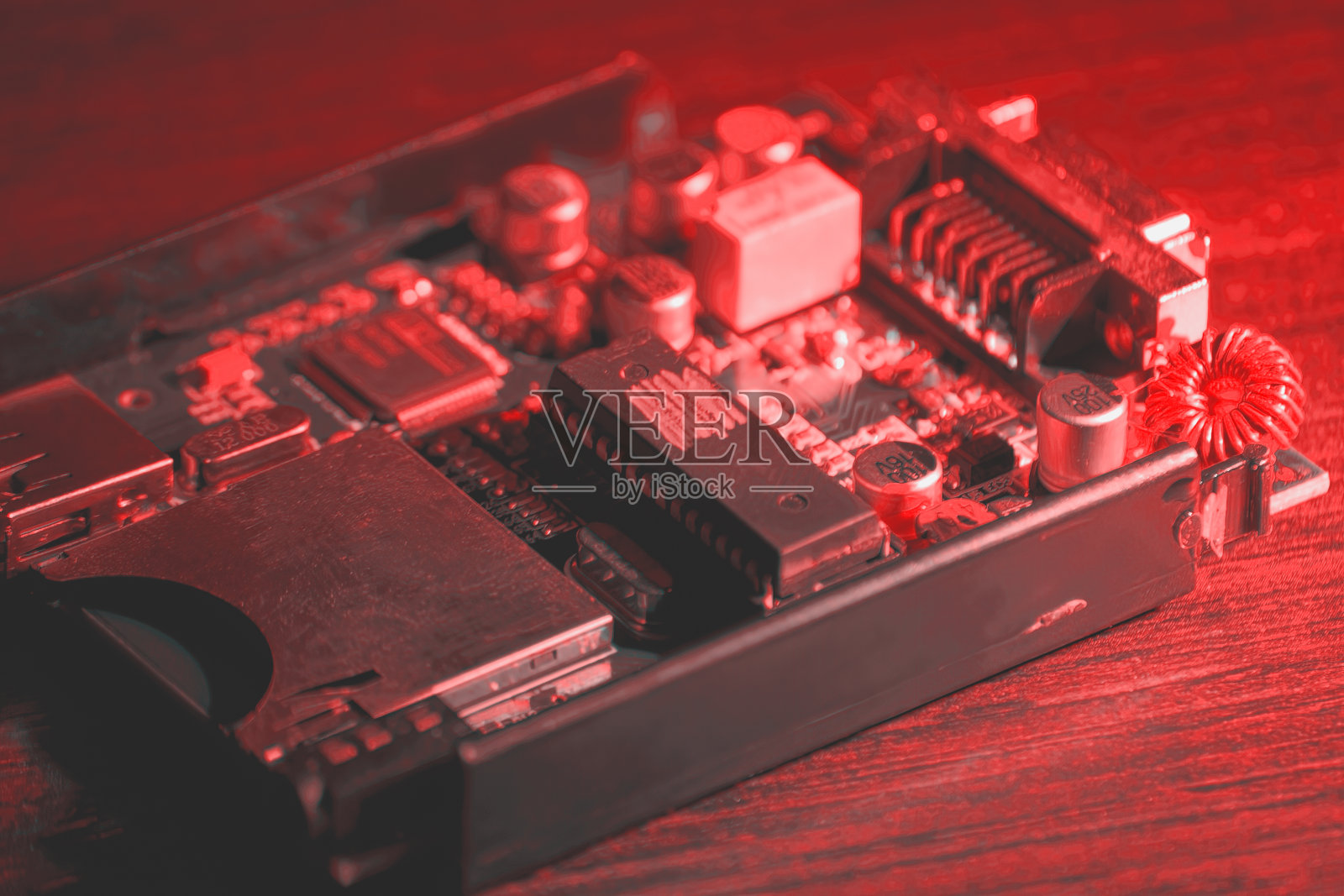 在粉红色的霓虹灯下，桌子上的小PCB和处理器照片摄影图片