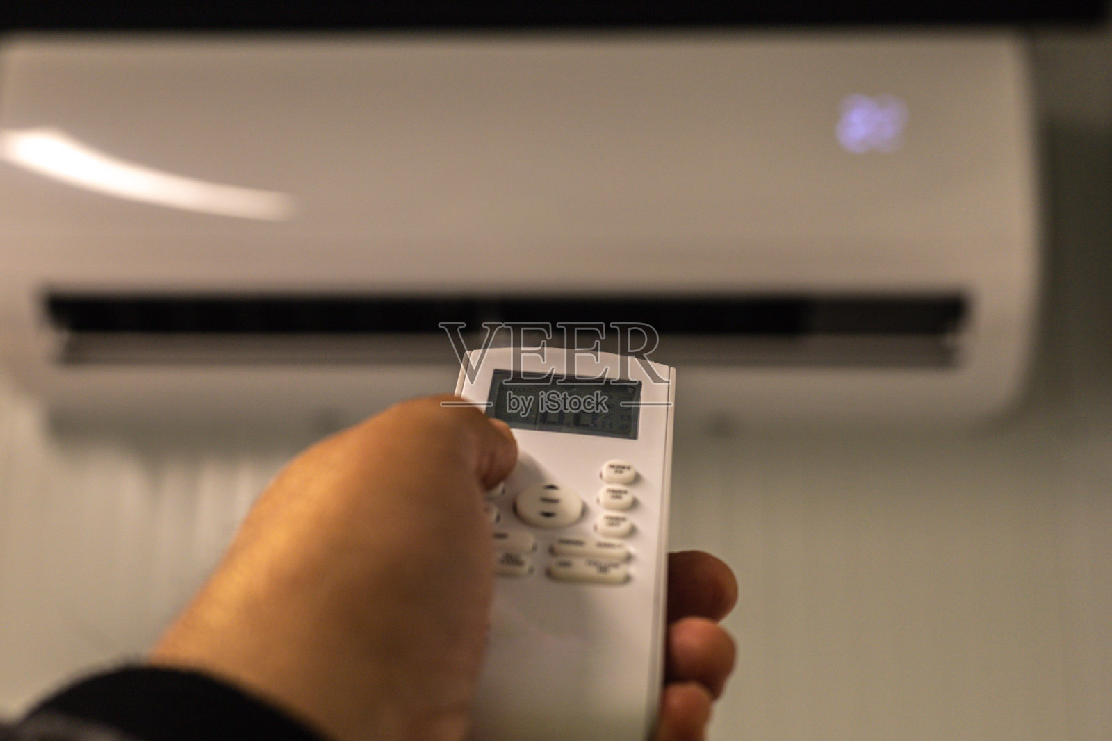 手拿空调控制装置来设定所需的温度并关闭电源消耗照片摄影图片