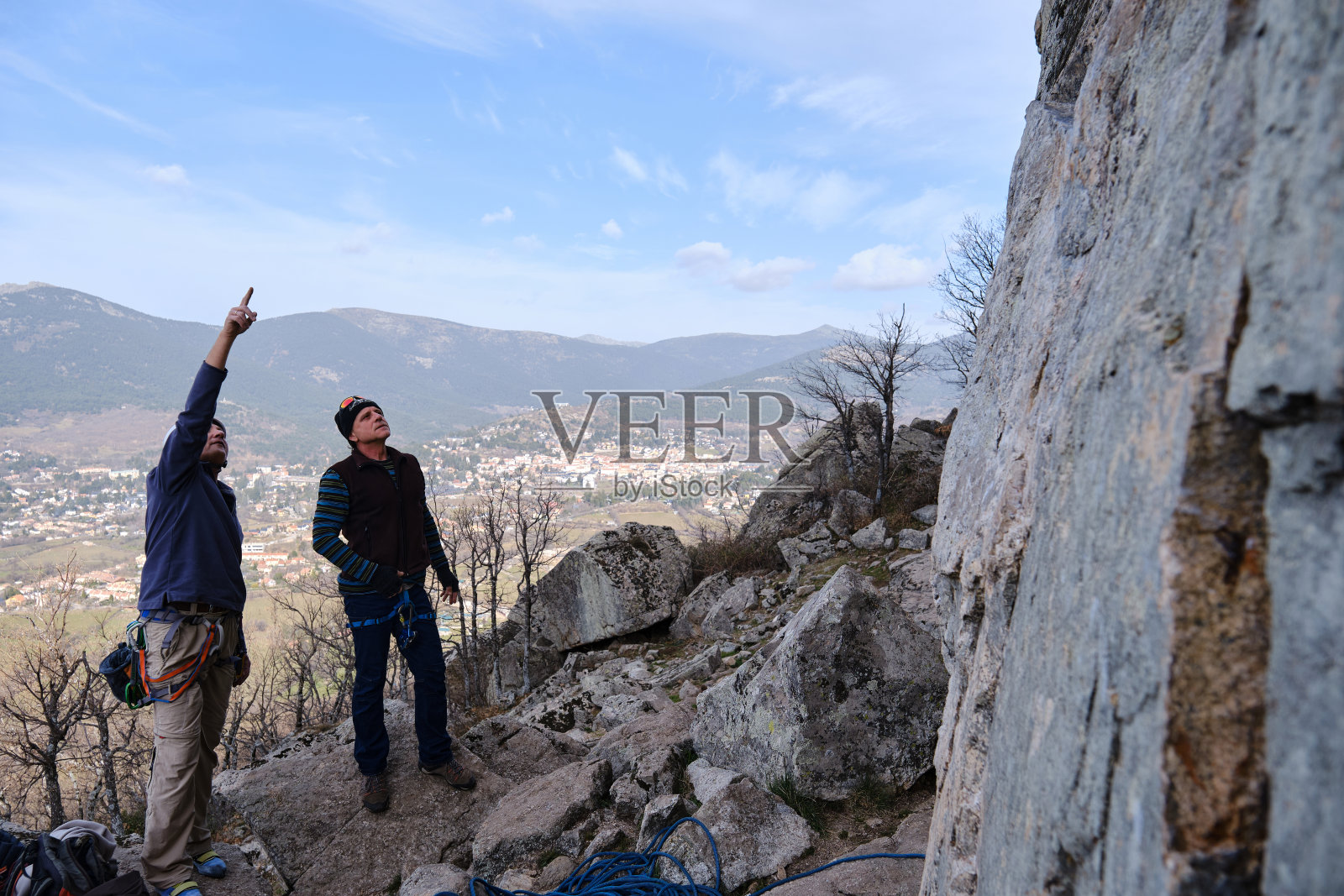 登山运动员在开始攀登岩石前仔细检查了路线。照片摄影图片