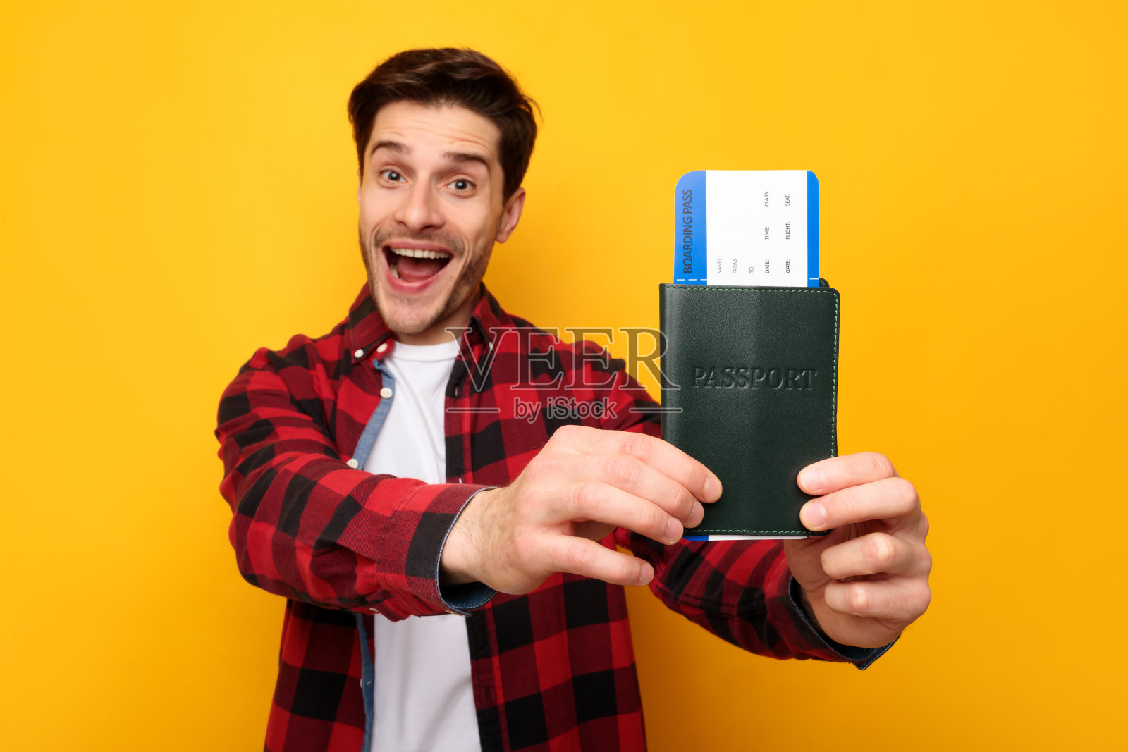 激动的年轻人拿着证件和护照照片摄影图片