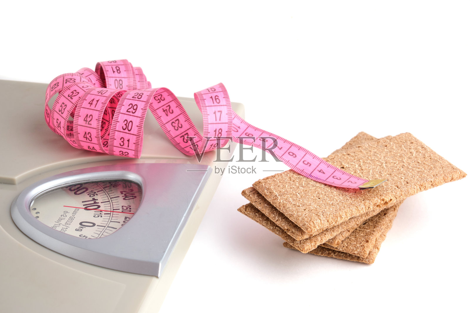 地秤，黑麦面包和卷尺在白色的背景上。健康的减肥食品。照片摄影图片