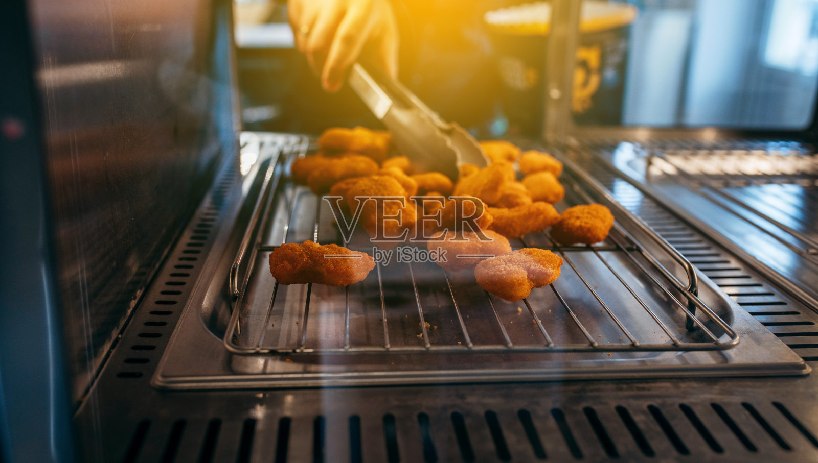 厨师的手拿着酥脆的鸡块在餐厅里的特写镜头照片摄影图片
