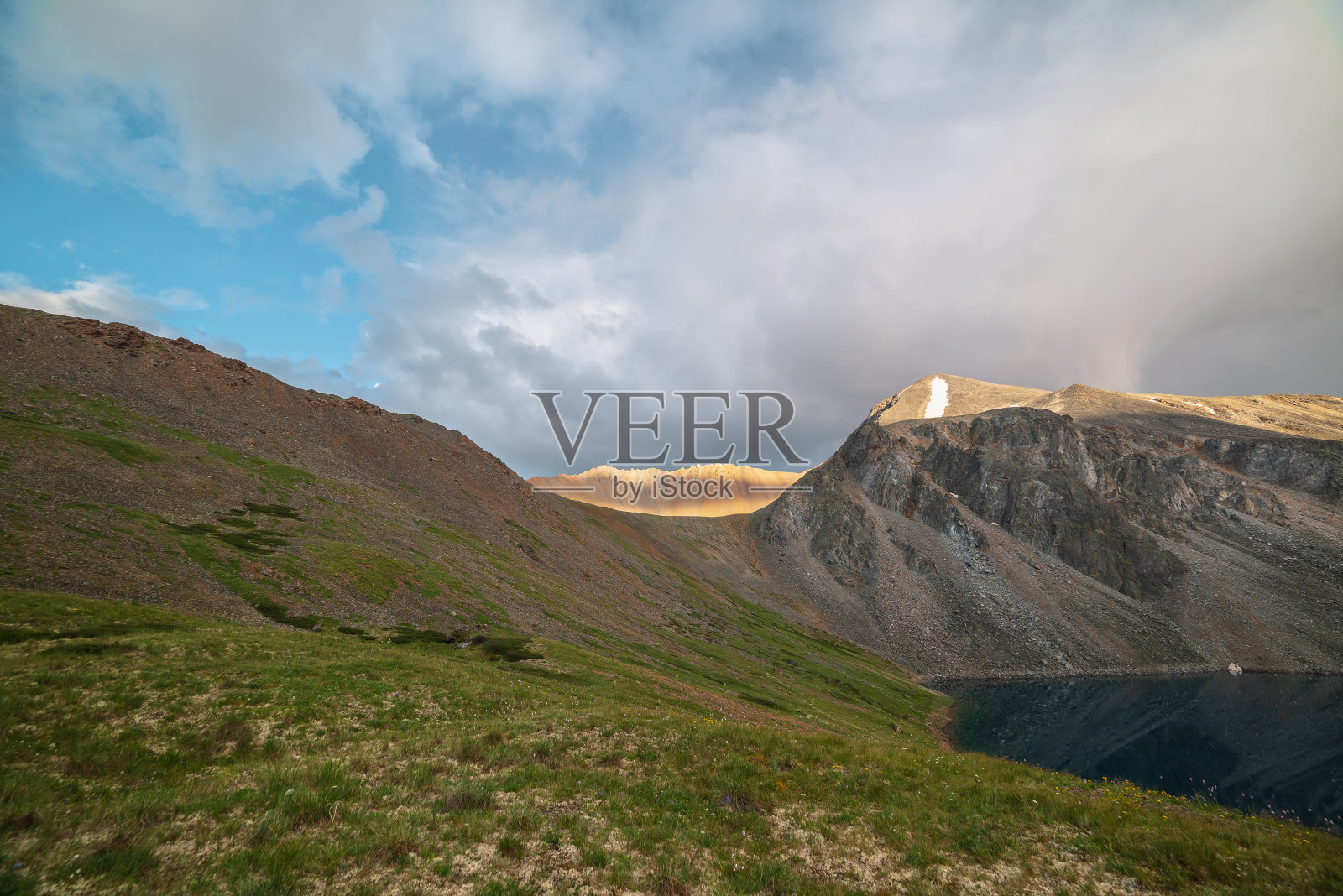 戏剧性的景观，阳光照射下的宽而尖锐的山脊，在多变的天气下，云的阴影。大气的山景与大尖锐的岩石在山脊顶部在阳光下多云的天空。照片摄影图片