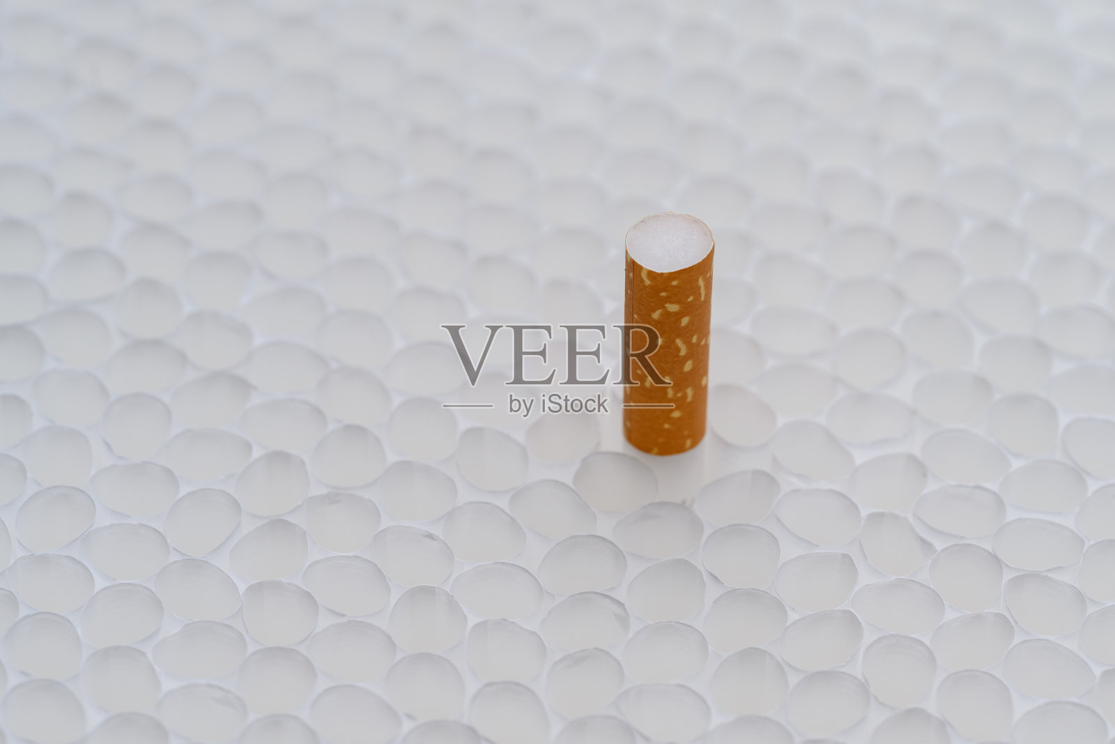 从无数根香烟中挑出一个带过滤嘴的空烟盒。柔和的灯光照片摄影图片