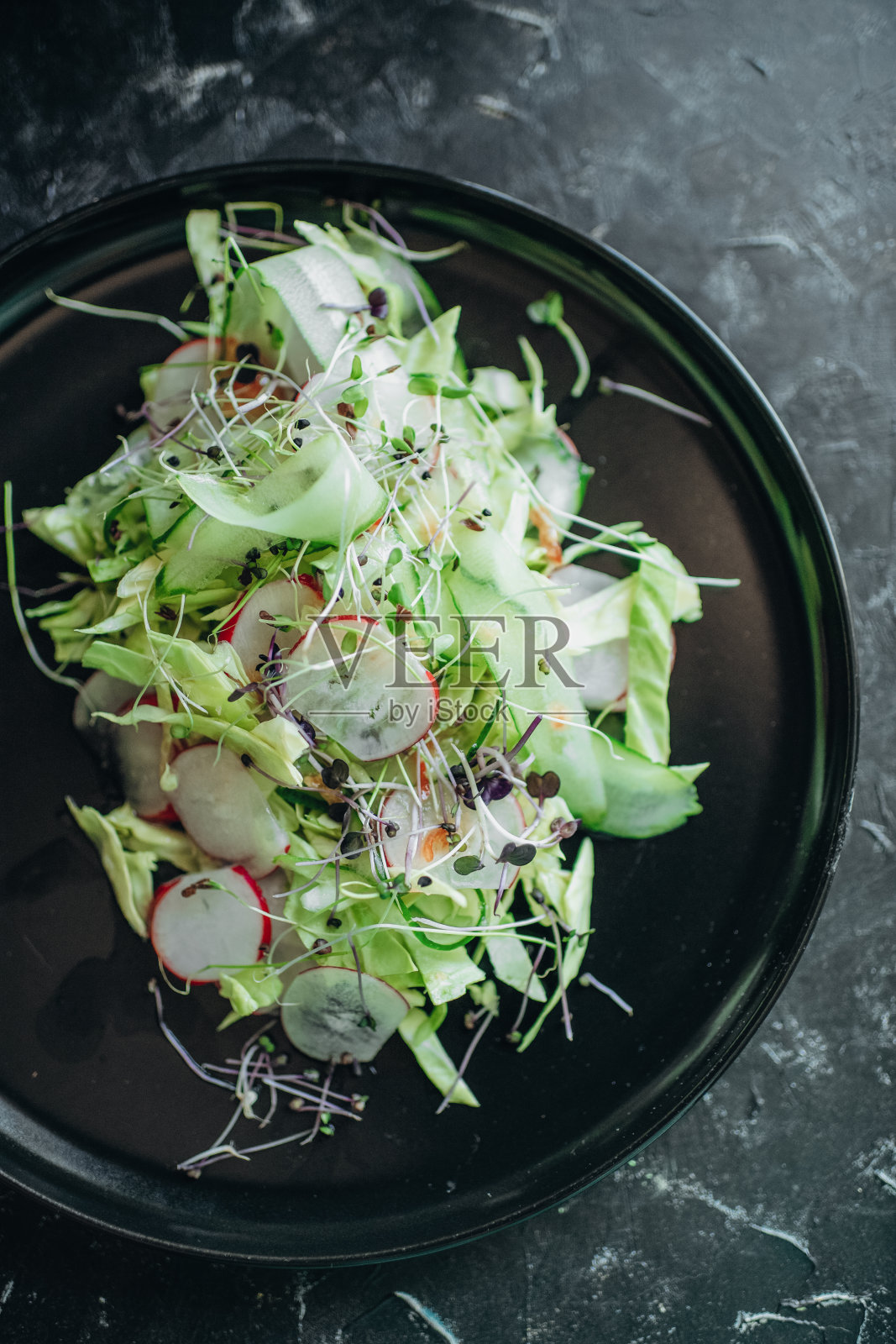 黑色盘子里的新鲜蔬菜沙拉和绿叶蔬菜照片摄影图片