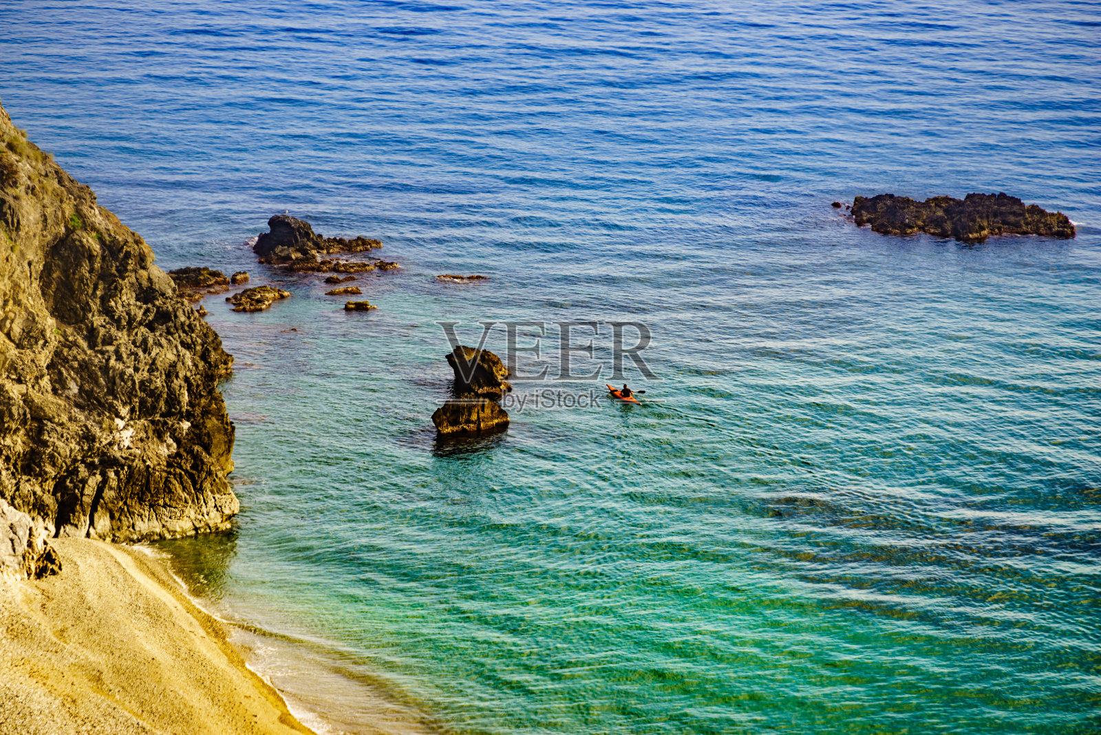 岩石海岸与人皮划艇照片摄影图片