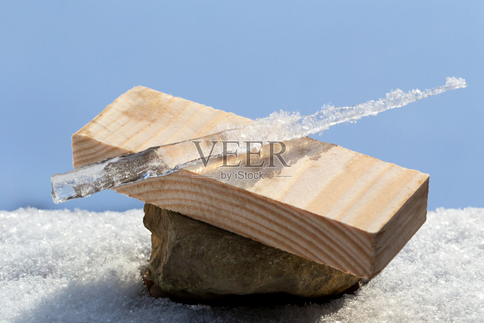 雪中的石头、木头、冰柱照片摄影图片