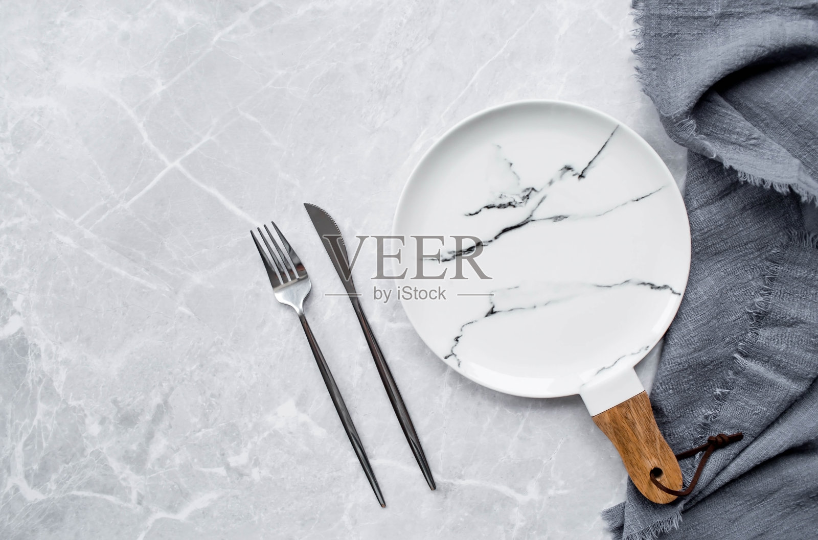横幅。一个空的陶瓷大理石盘子，木柄，叉子，刀子和毛巾，背景是灰色的混凝土桌子。空间的文本。咖啡馆和餐厅的菜单概念。照片摄影图片