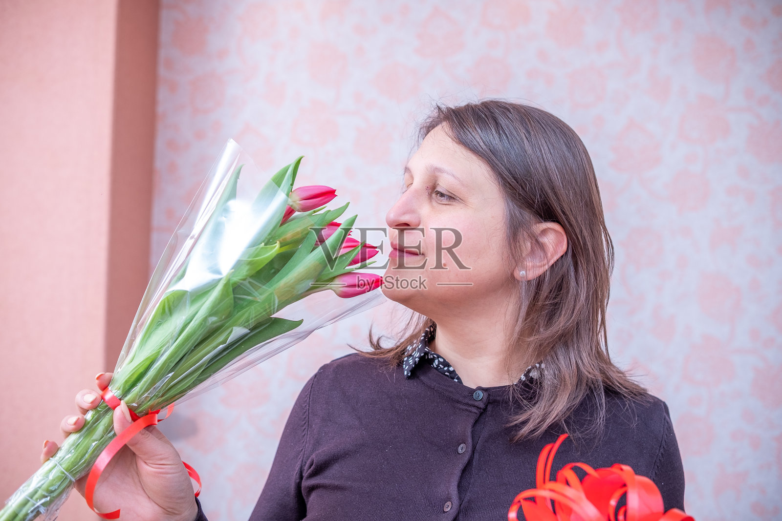 一个年轻快乐的女人正为她的礼物和一束郁金香而高兴照片摄影图片