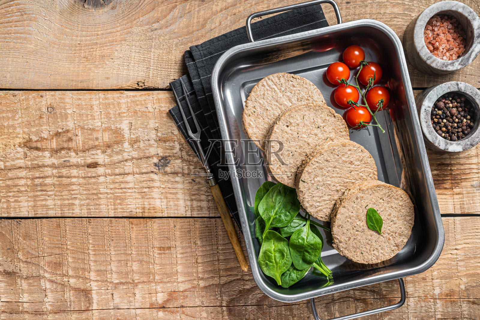 生肉免费肉饼由植物为基础的肉，新鲜的素食汉堡肉排在厨房托盘与香草。木制背景。前视图。本空间照片摄影图片