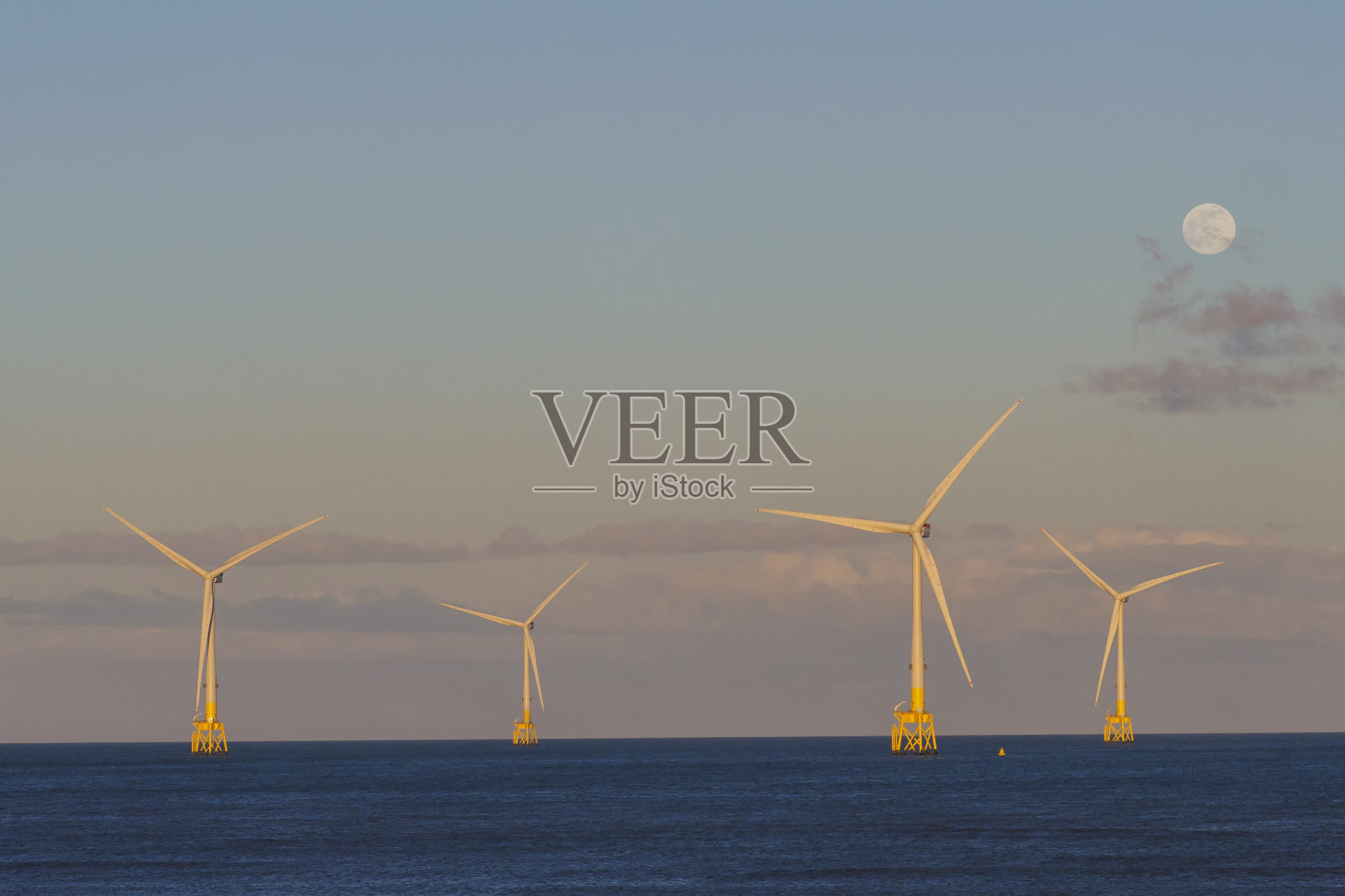 月亮升起下的海上风力涡轮机照片摄影图片