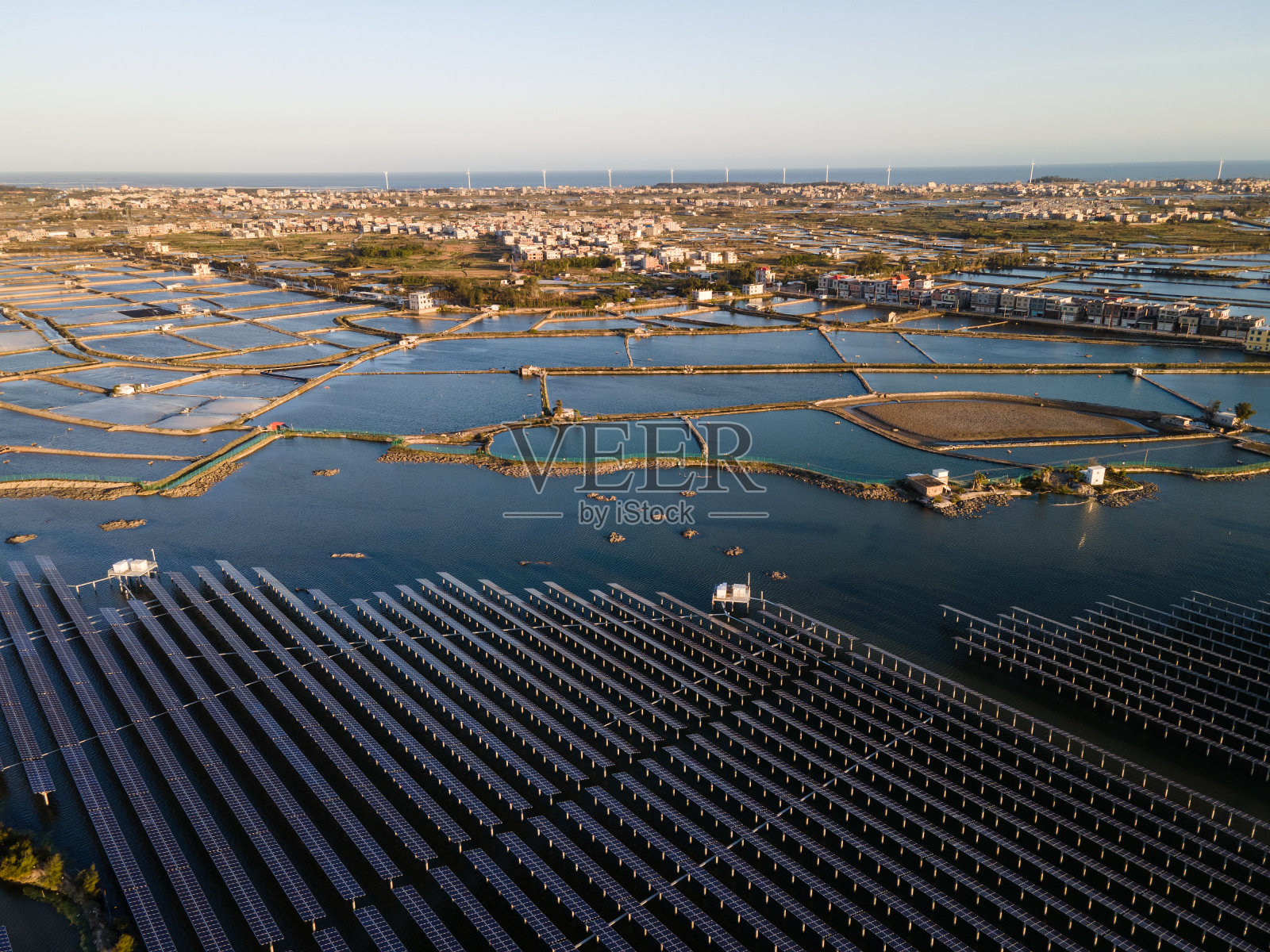 日落时海上太阳能发电厂的鸟瞰图。照片摄影图片