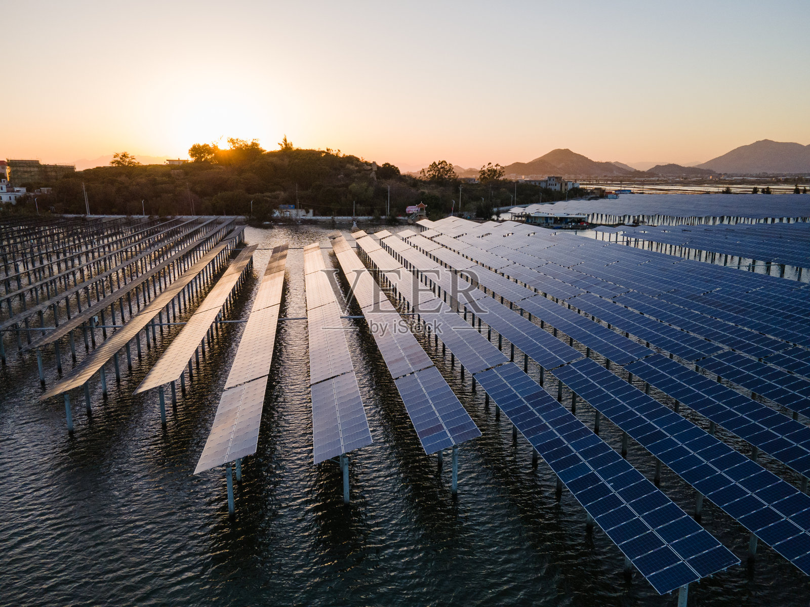 日落时海上太阳能发电厂的鸟瞰图。照片摄影图片