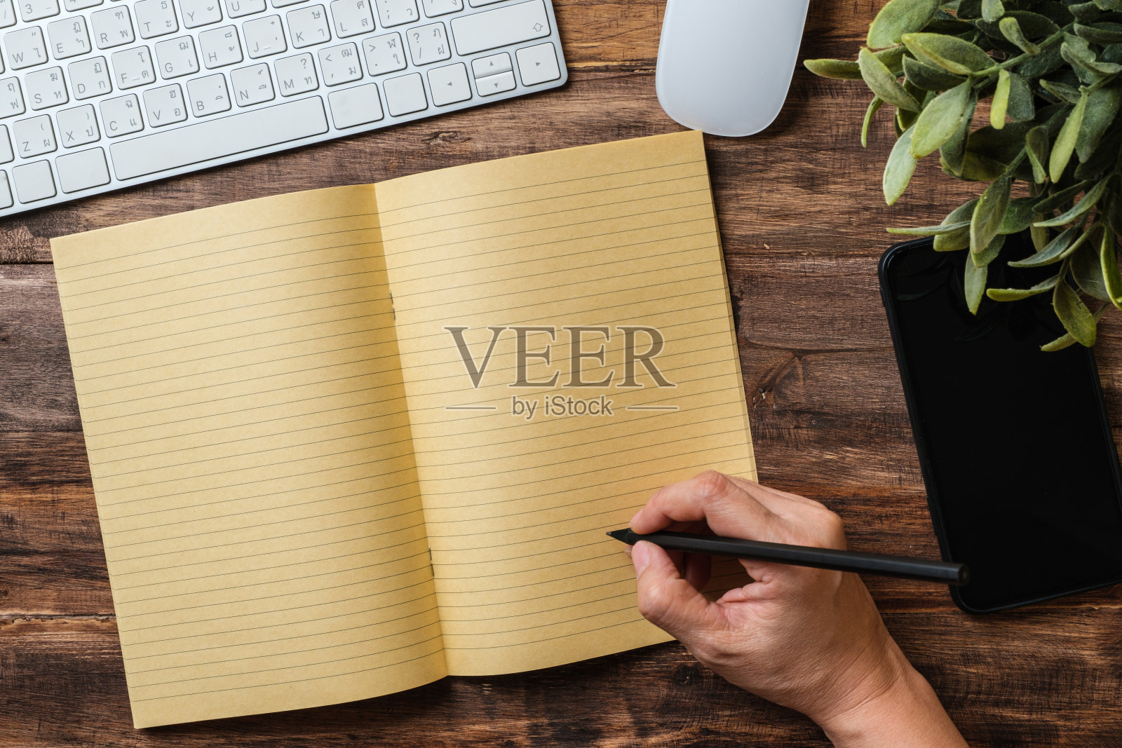 俯视图在笔记本上手写，电脑放在家里的木桌上照片摄影图片