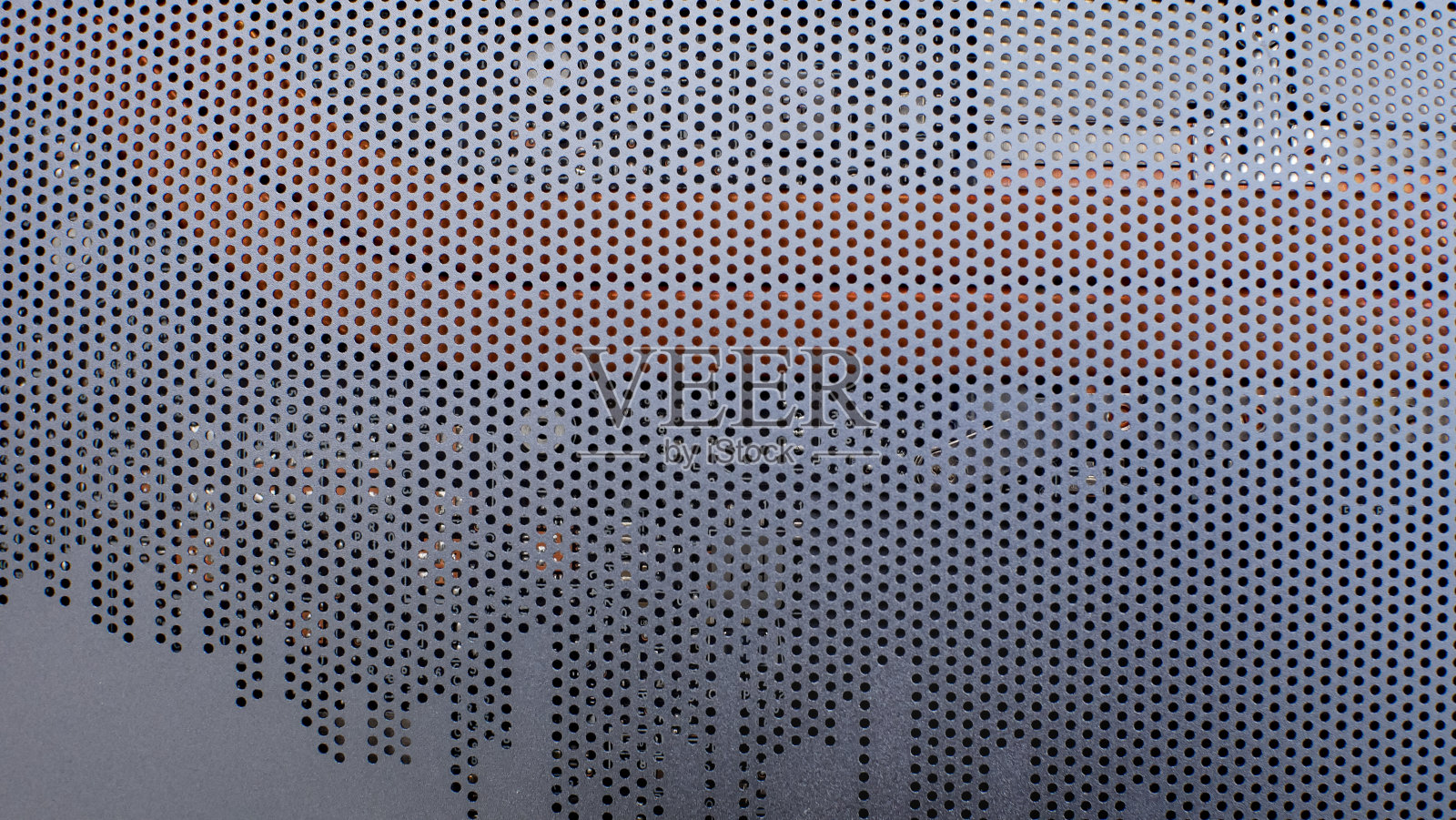 金属格栅纹理的笔记本电脑的情况。带圆孔的金属格栅盖在电脑外壳上照片摄影图片