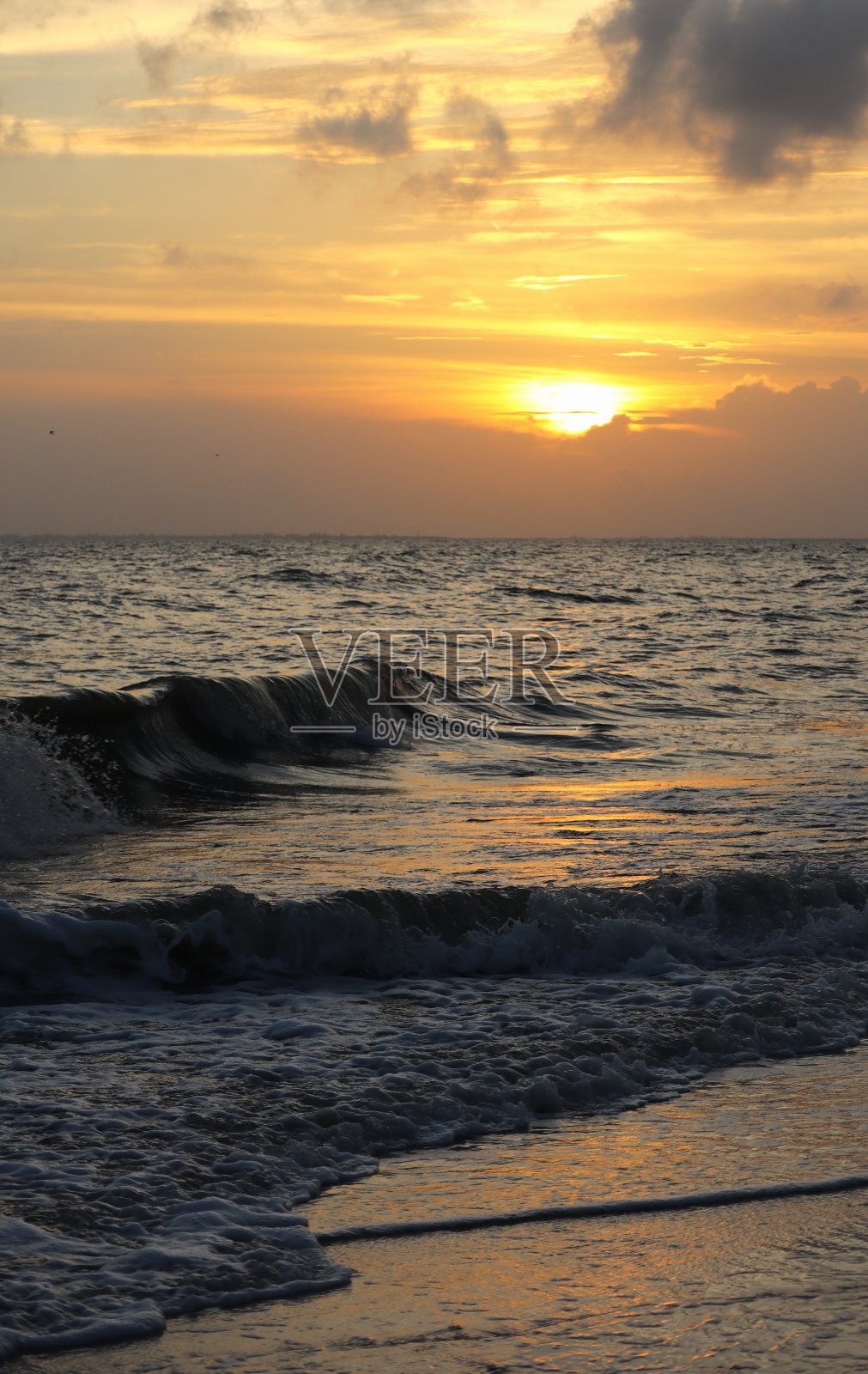 夕阳西下，波涛汹涌照片摄影图片