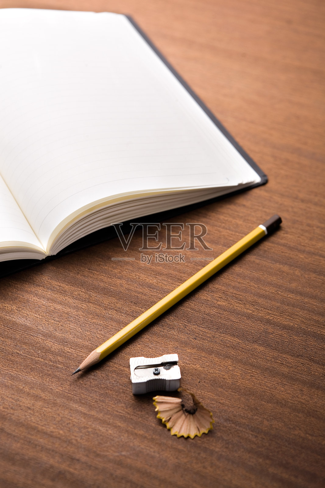 在木桌上打开空白的笔记本，铅笔，卷笔刀和铅笔刨花照片摄影图片