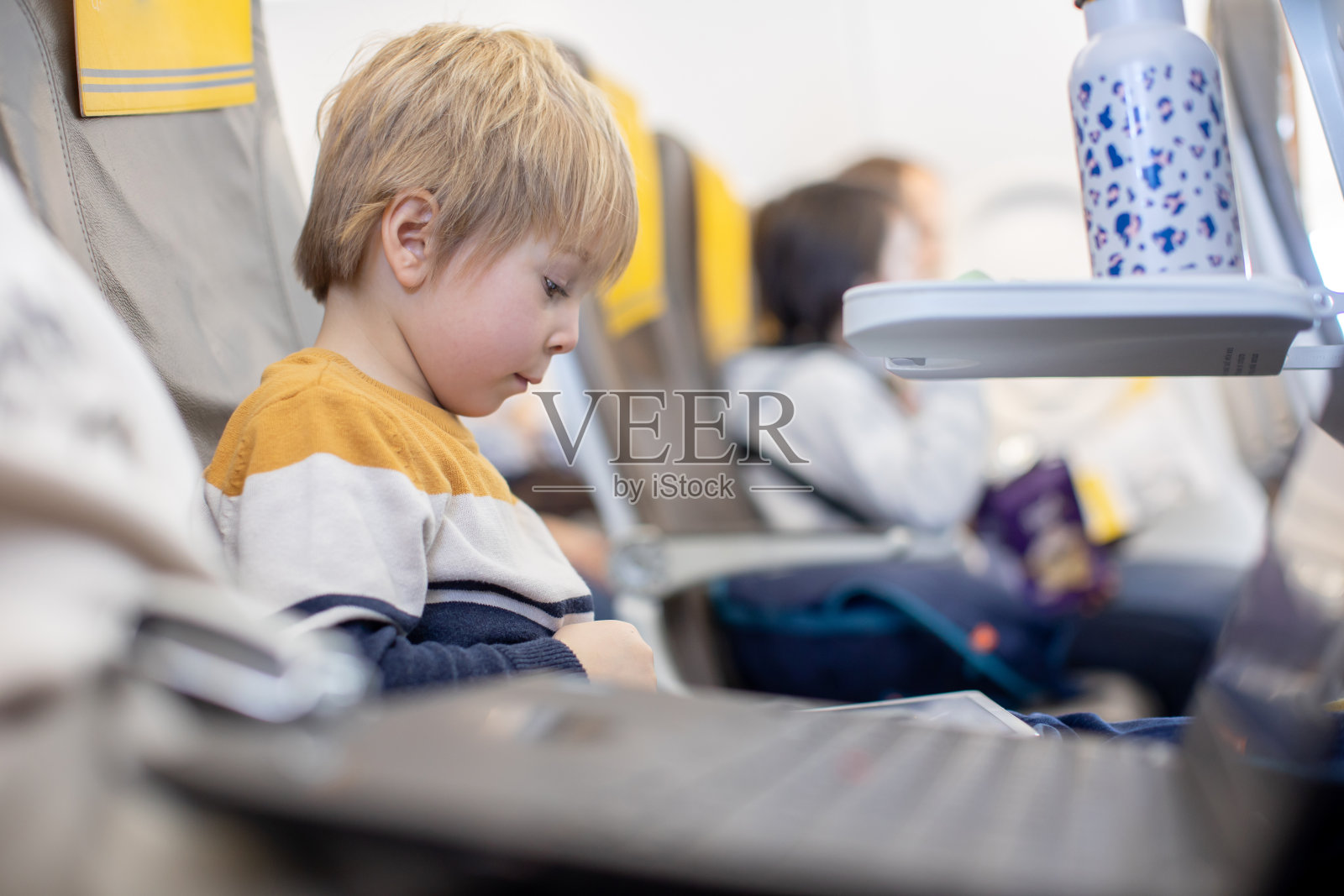 孩子，男孩和妈妈，坐在飞机上，孩子玩平板电脑照片摄影图片