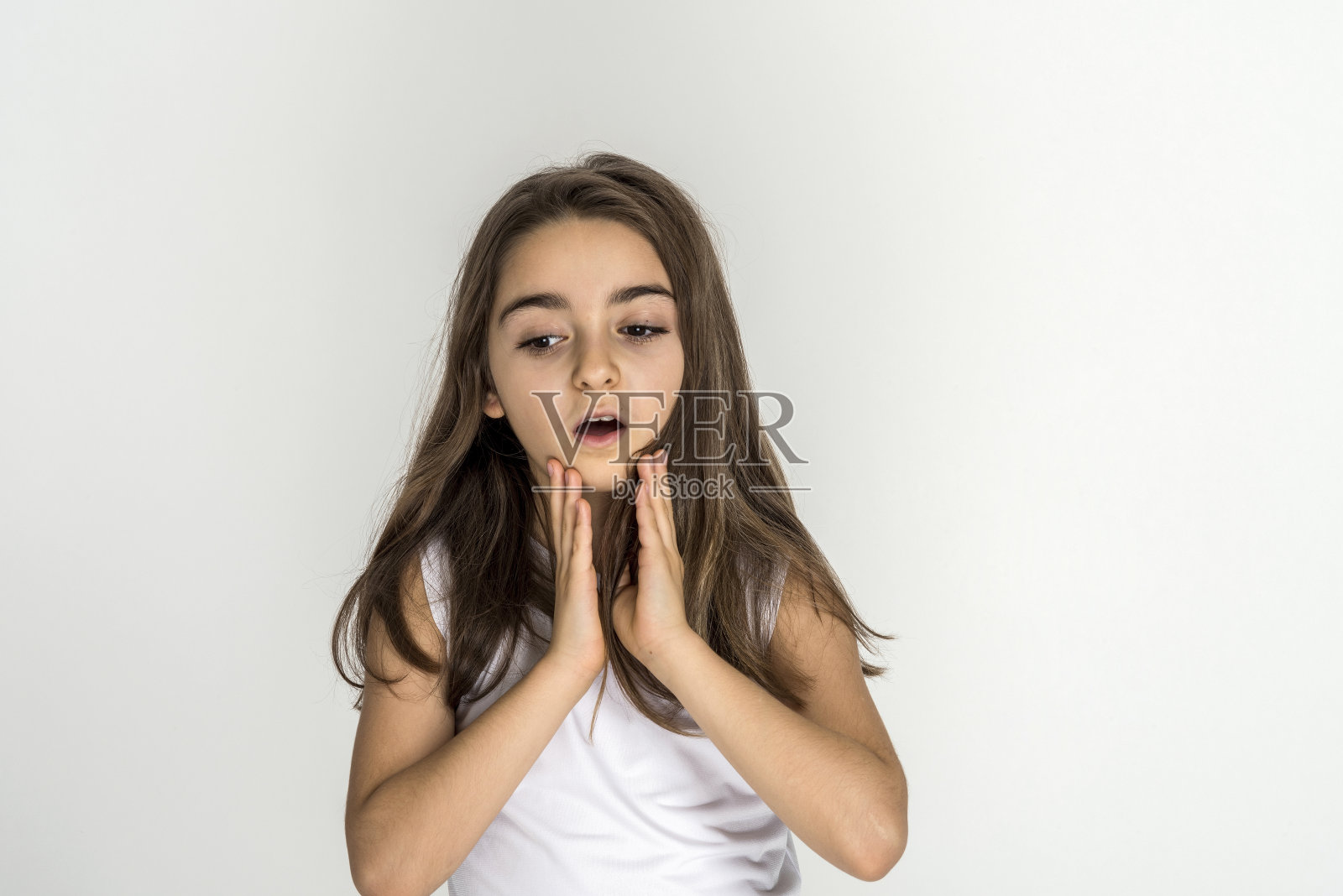 震惊的小女孩的肖像，双手放在她的下巴照片摄影图片
