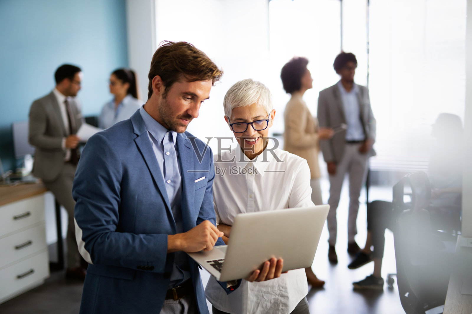 成功的商业人士在公司办公室一起工作的肖像。照片摄影图片