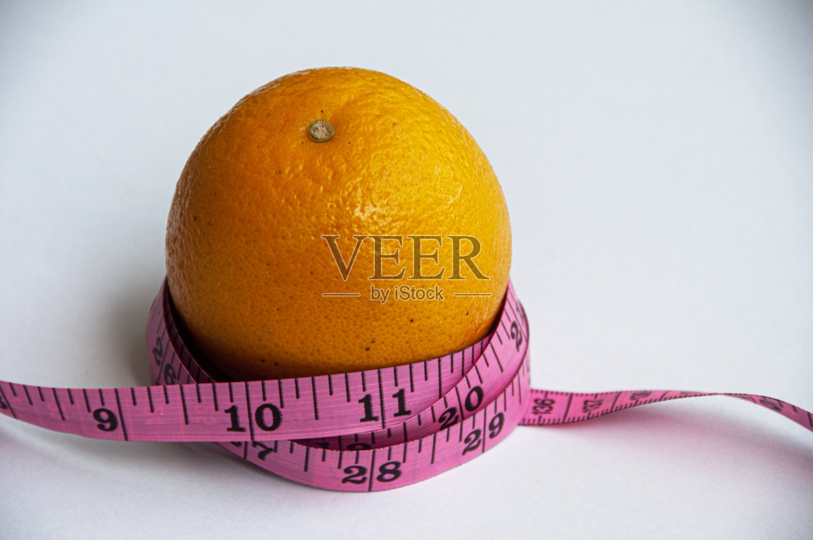 卷尺和白色背景下的橙色。减肥的概念照片摄影图片