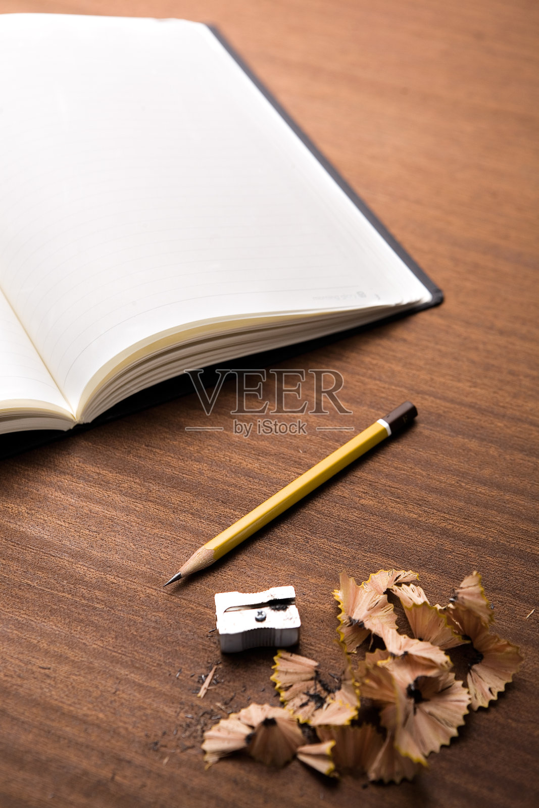 在木桌上打开空白的笔记本，铅笔，卷笔刀和铅笔刨花照片摄影图片