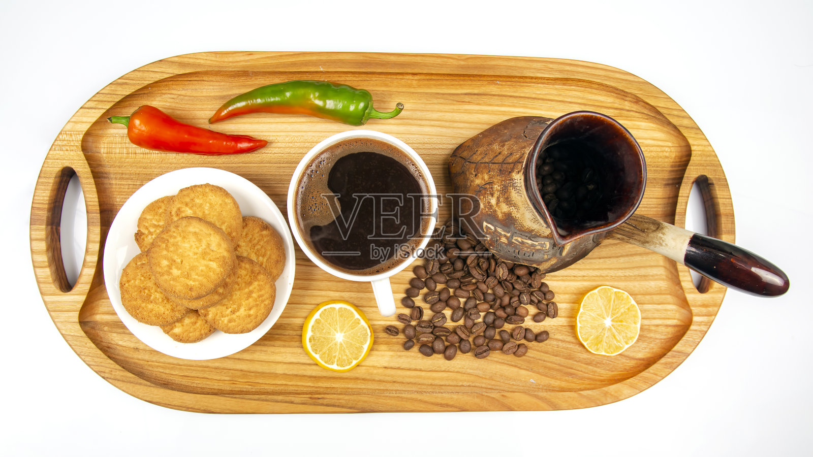 新煮的热黑咖啡在一个白色的杯子在木板上的咖啡豆。辣椒和柠檬照片摄影图片