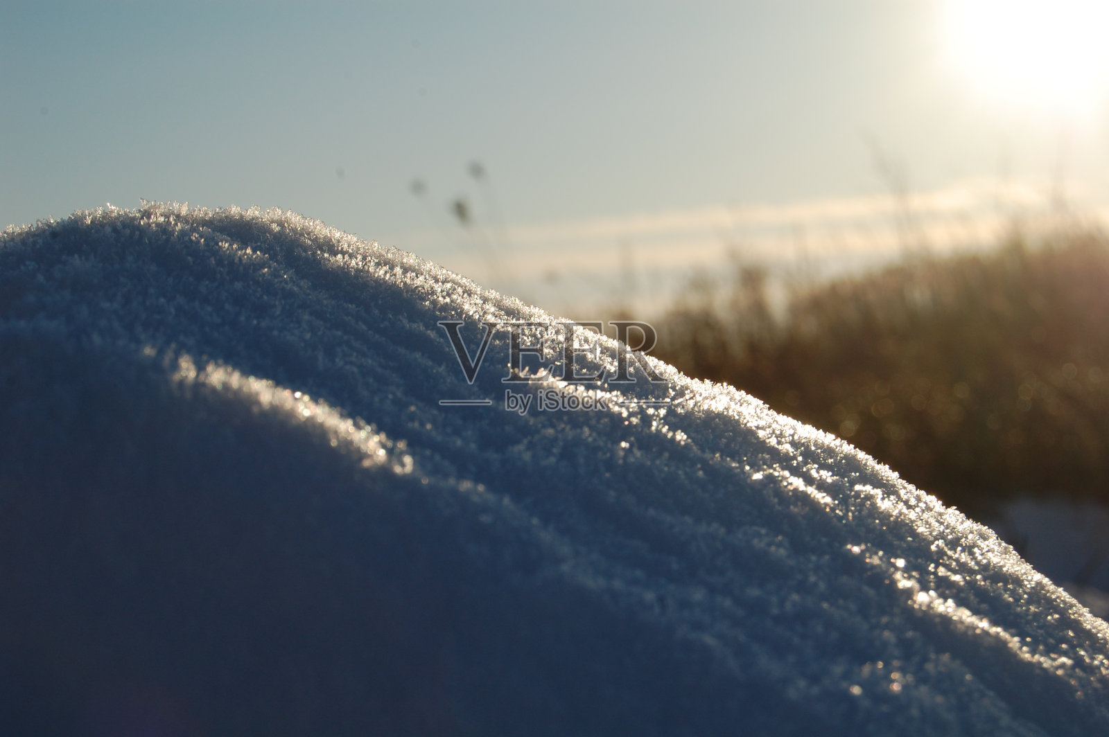雪在阳光下闪闪发光。照片摄影图片