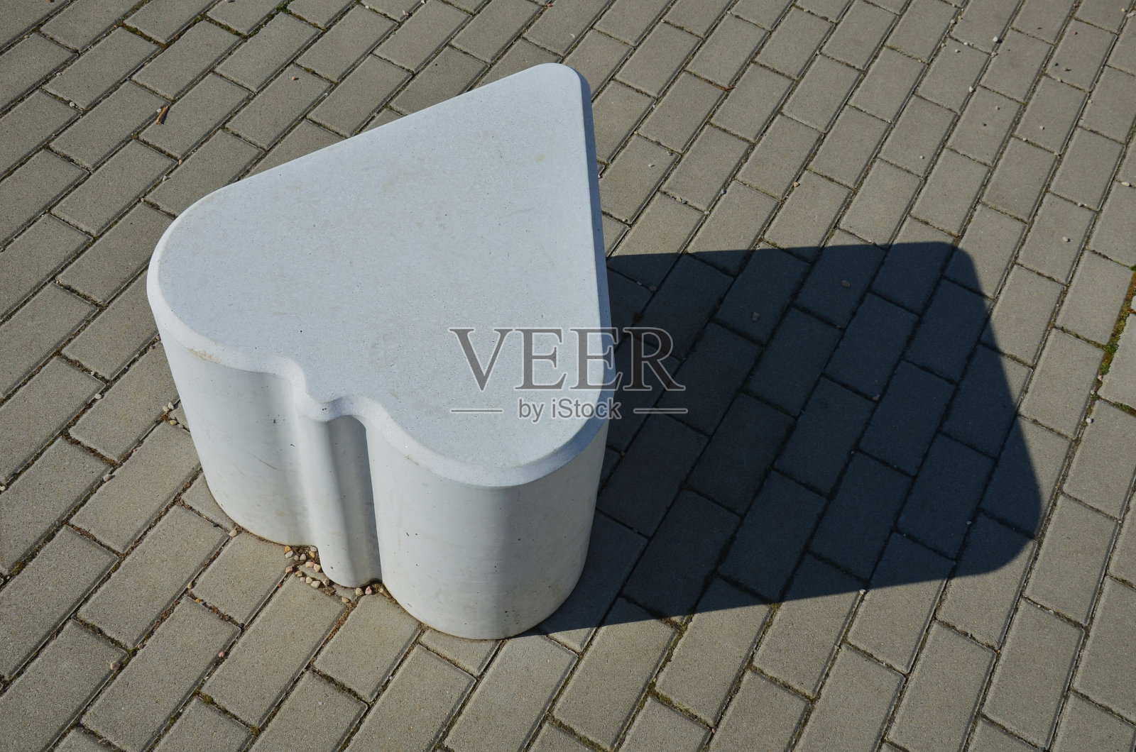 光滑的椅子大小的混凝土铸件。适合作为城市设计屏障进入步行区。摩卡方糖的形状。玩卡那斯塔牌的符号。人行道上的白心照片摄影图片