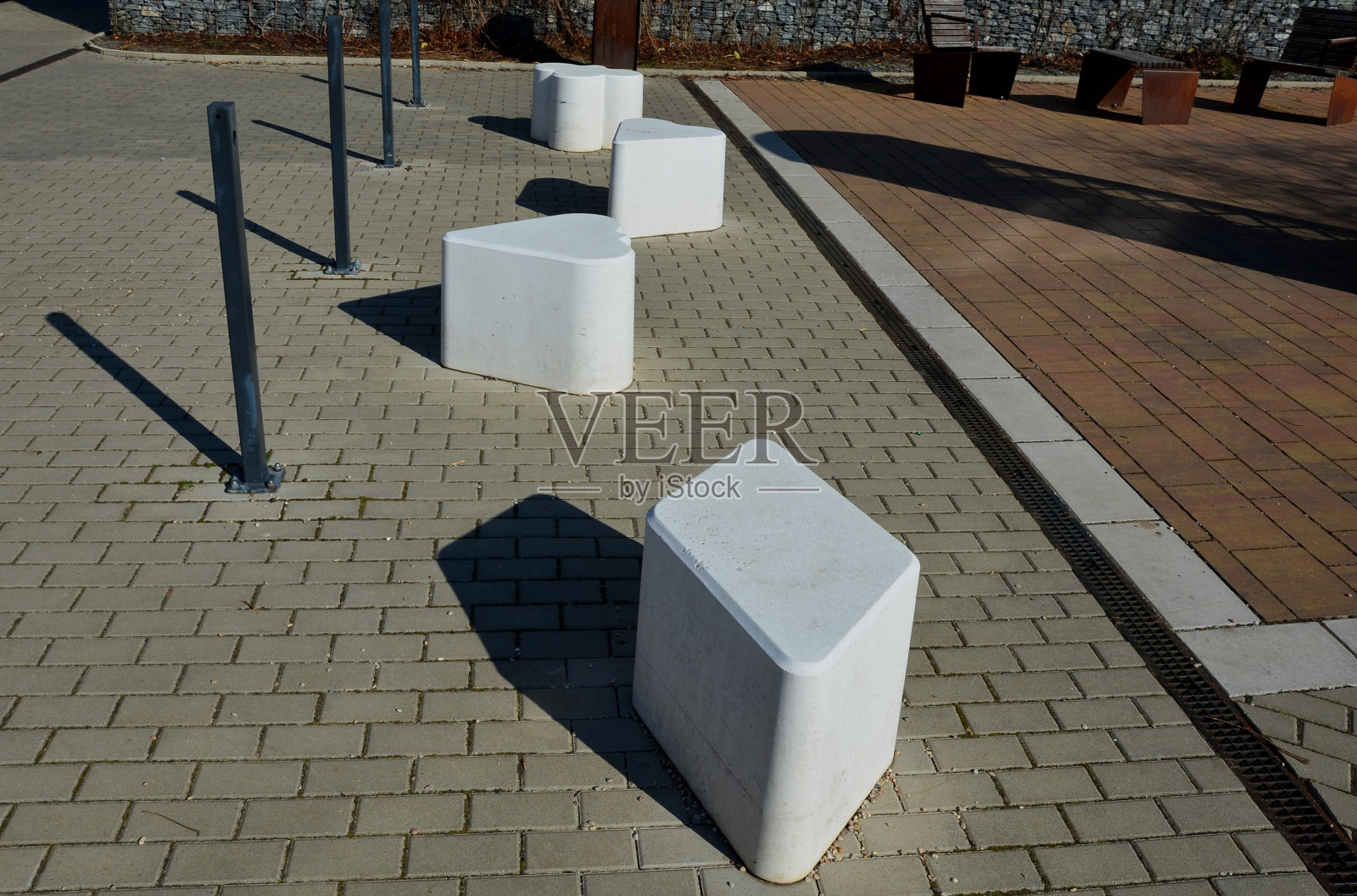 光滑的椅子大小的混凝土铸件。适合作为城市设计屏障进入步行区。摩卡方糖的形状。玩卡那斯塔牌的符号。人行道上的白心照片摄影图片