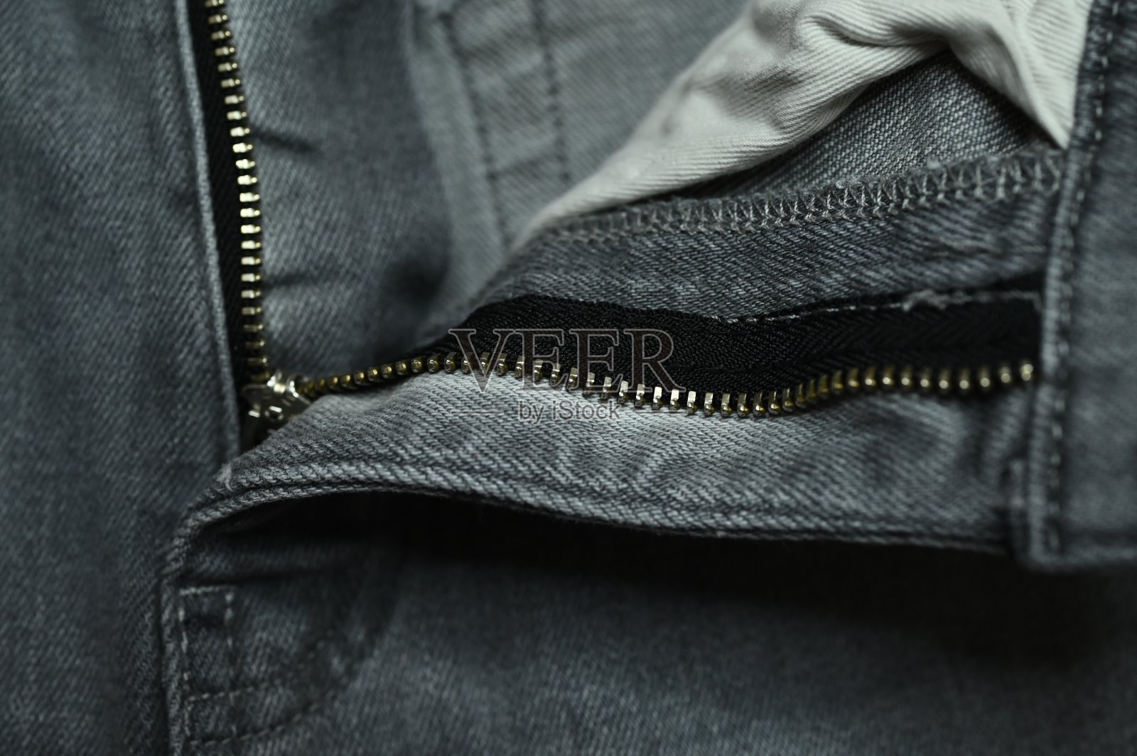 牛仔裤上的金属拉链照片摄影图片