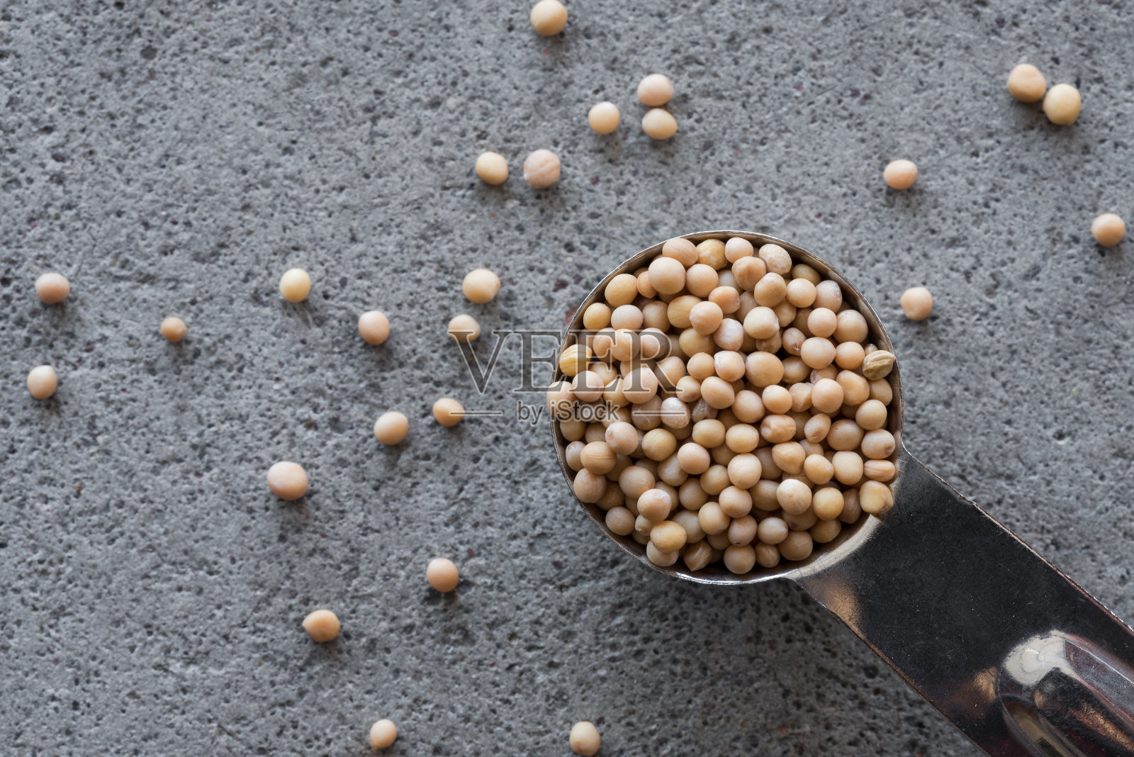 黄色芥末籽从茶匙中洒出来照片摄影图片