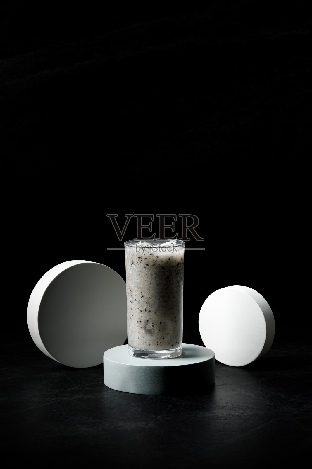 新鲜的龙果冰沙在黑色的背景玻璃。照片摄影图片