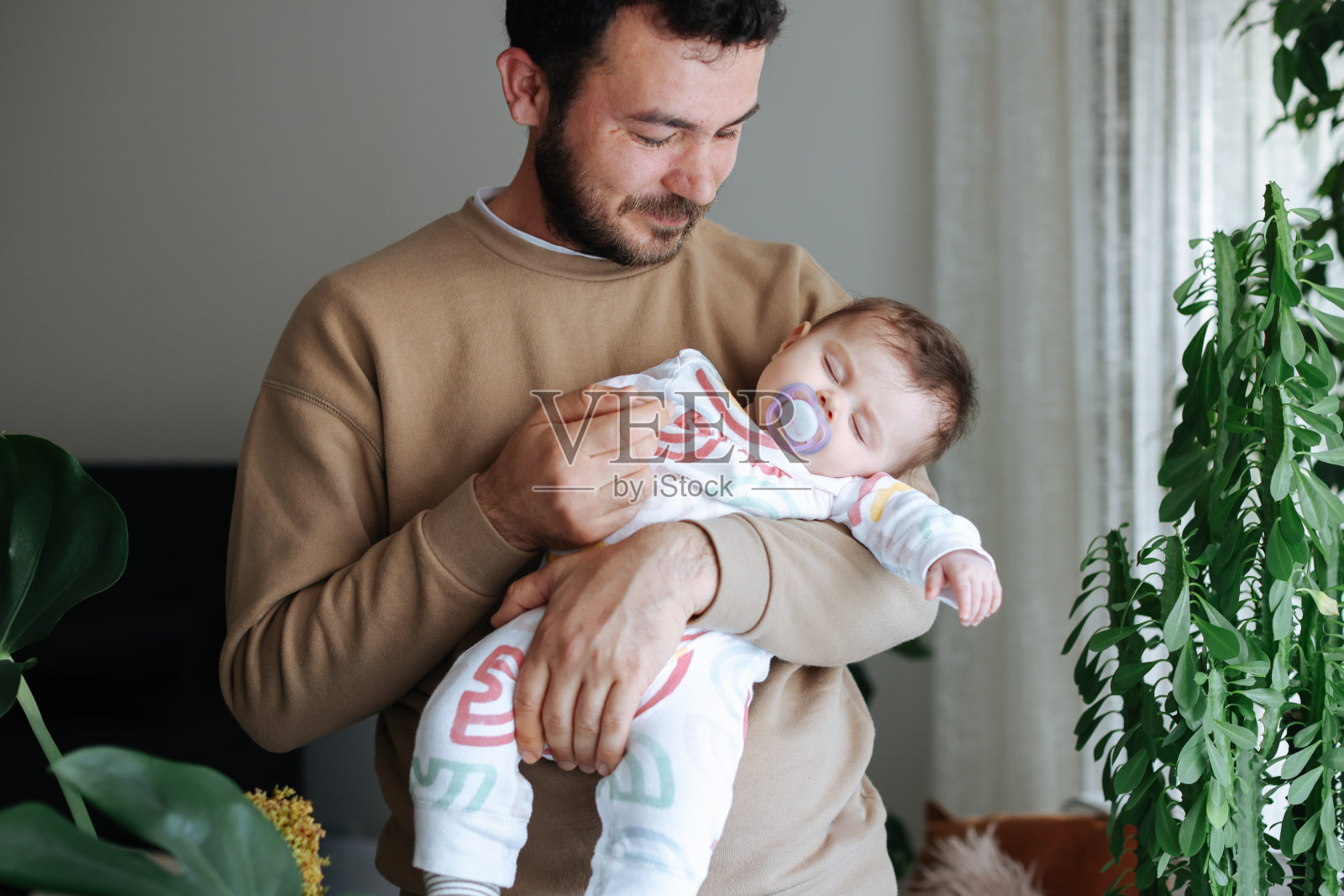 父亲抱着刚出生的儿子在托儿所照片摄影图片