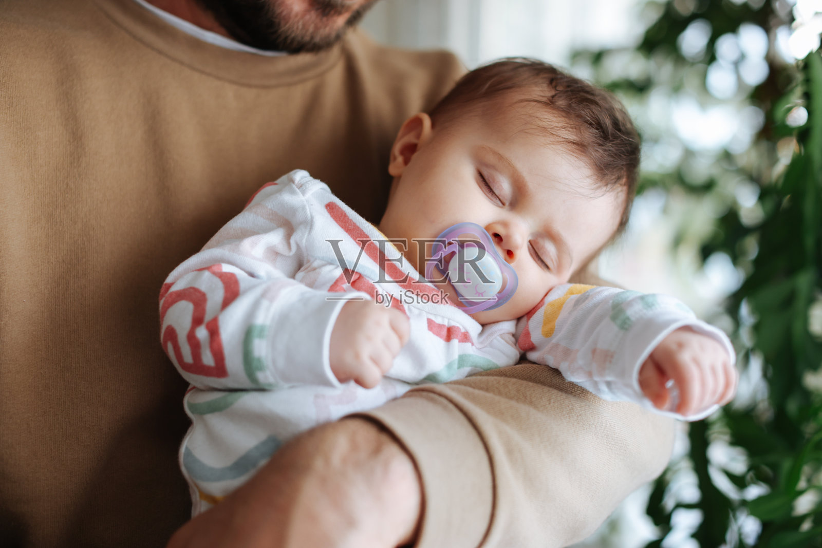 父亲抱着刚出生的儿子在托儿所照片摄影图片