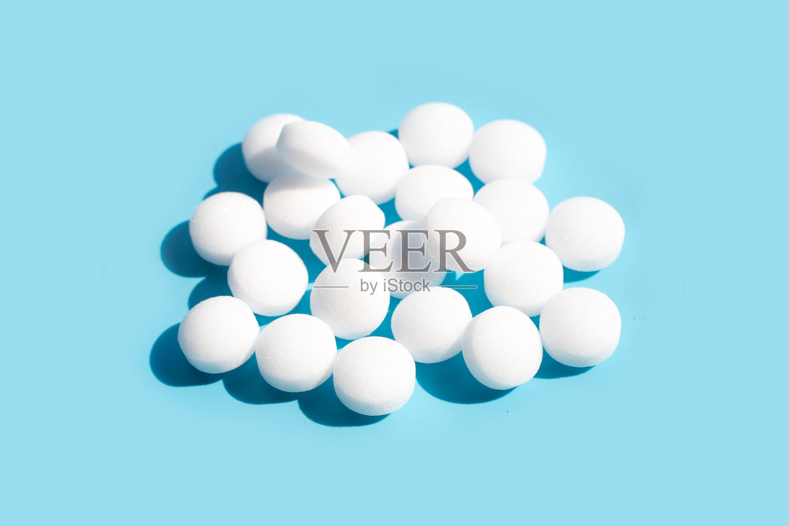 蓝色背景上的萘樟脑丸。照片摄影图片