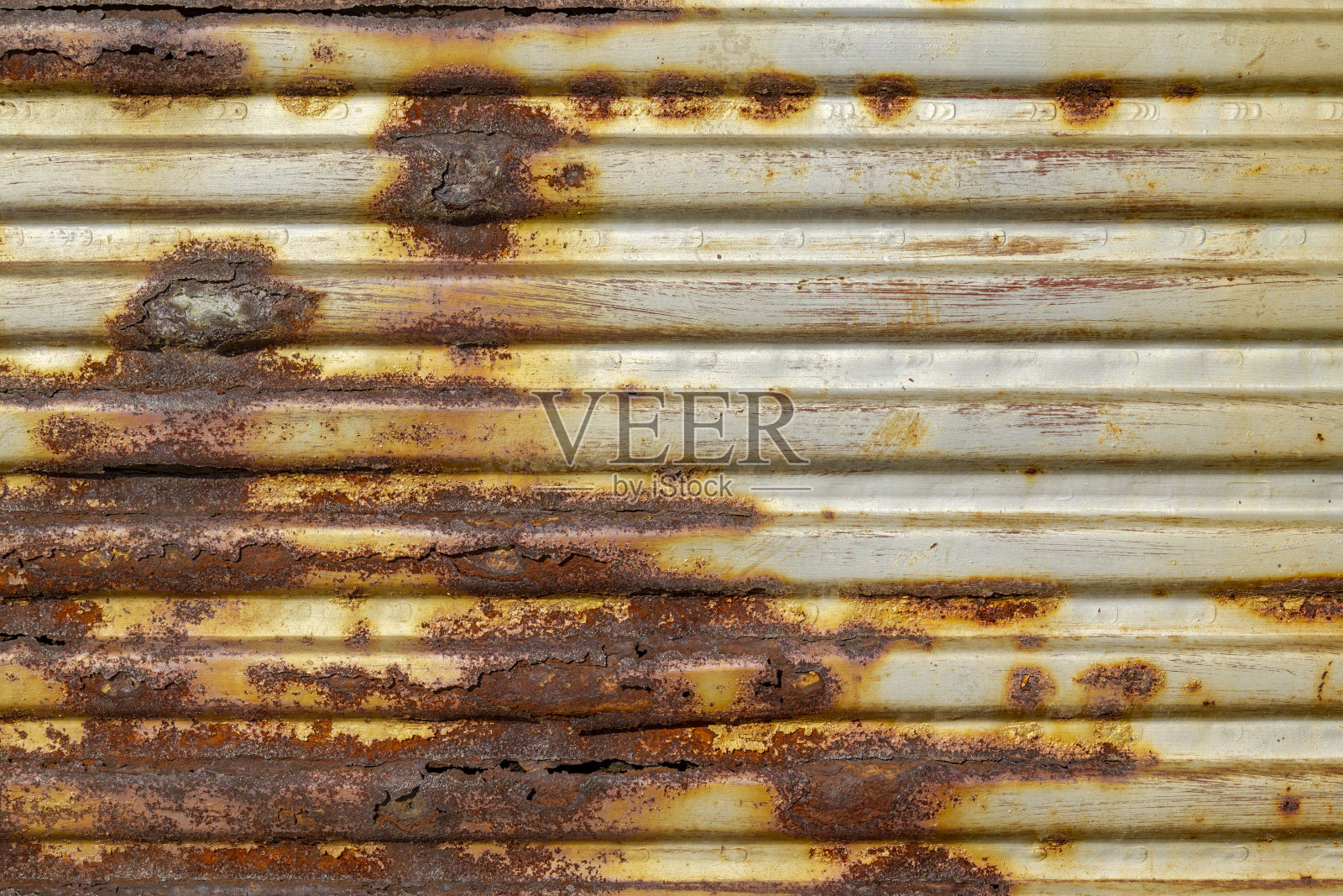 银色的抽象背景与粉红色的红棕色阴影。锈蚀的带棱纹纹理的金属片上还有残留的油漆痕迹。照片摄影图片