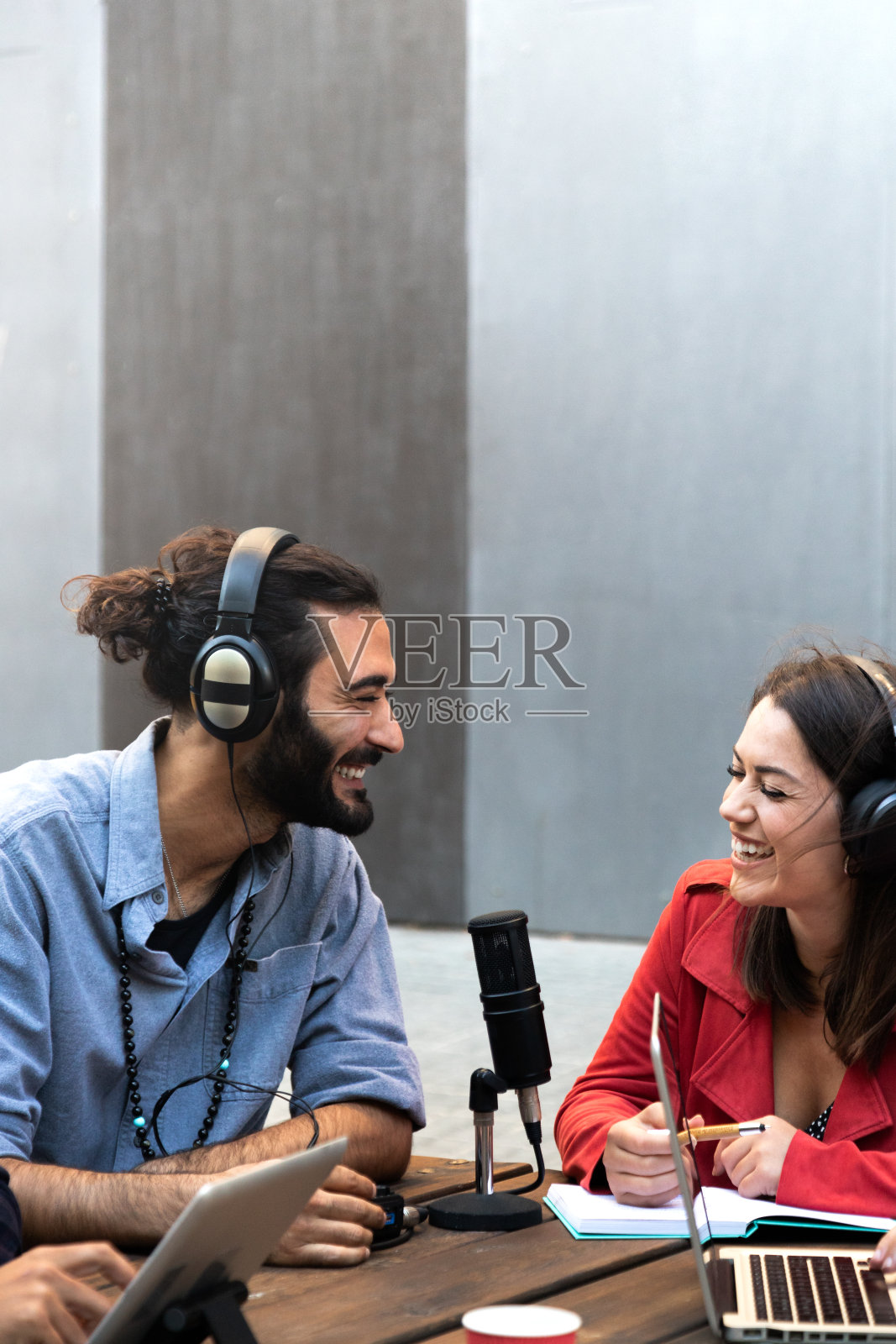 年轻的白人男女用笔记本电脑在线录制播客。垂直的图像。本空间照片摄影图片