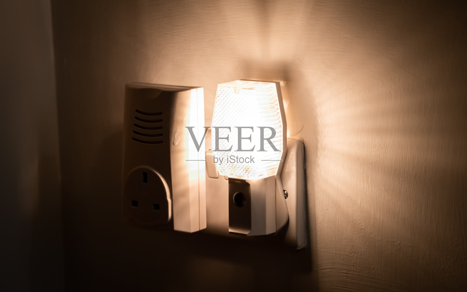 一盏插在房子墙上的夜灯的特写照片摄影图片