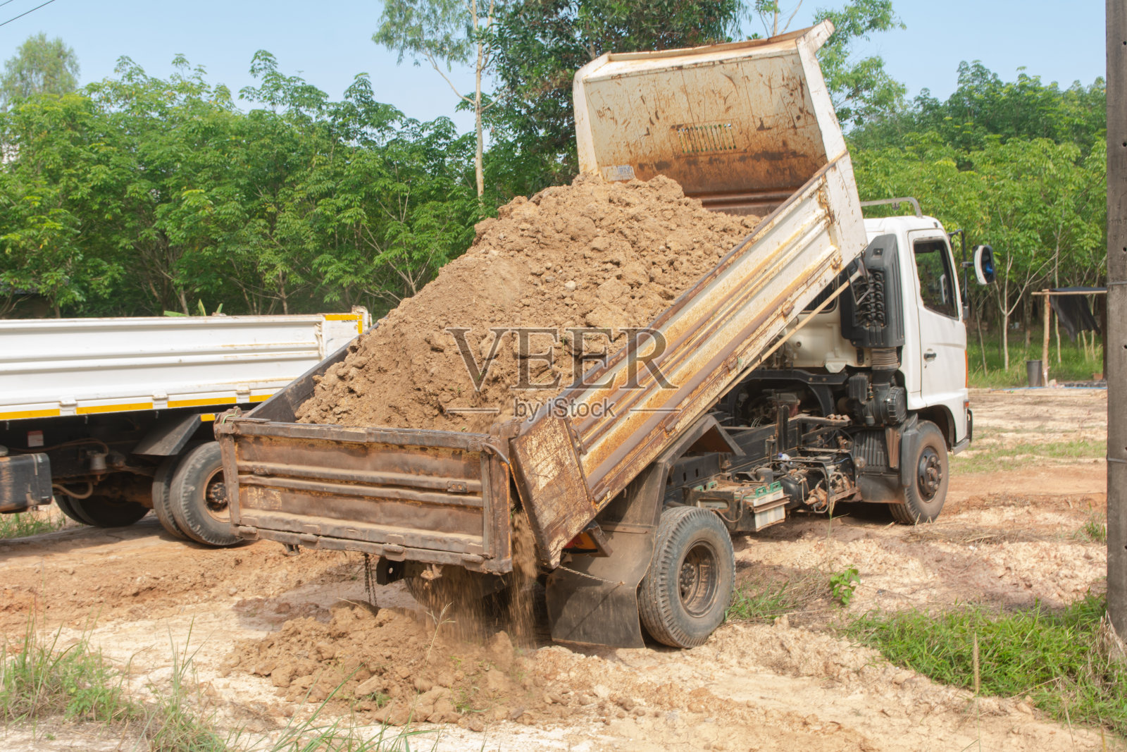 自卸卡车在工地卸土照片摄影图片