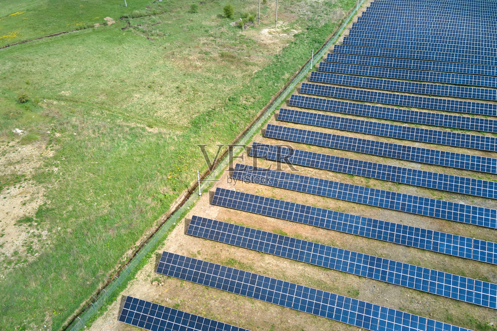 绿色田野上的太阳能发电厂鸟瞰图。带有面板的生产清洁生态能源的电农场照片摄影图片