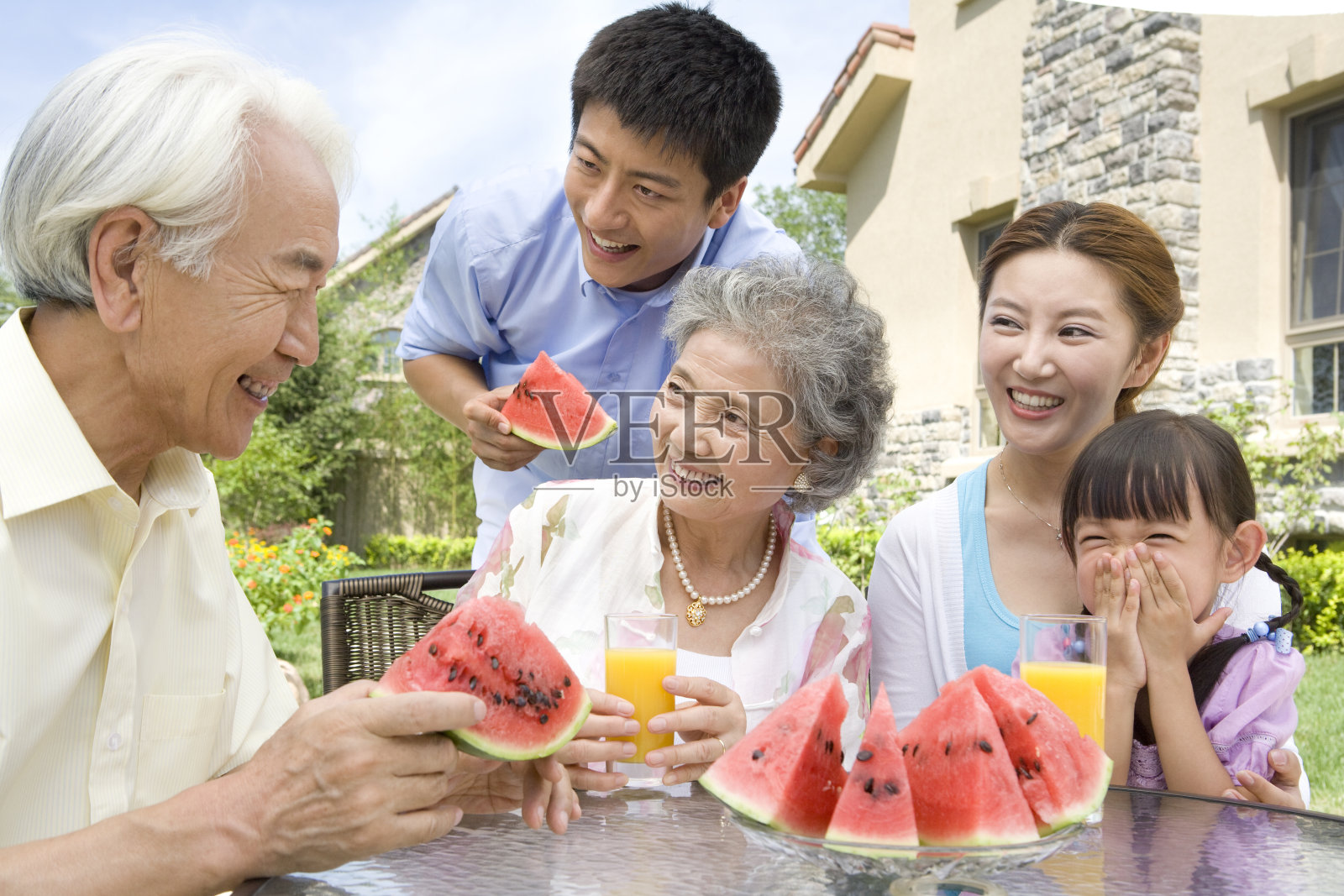 全家人在庭院里吃水果照片摄影图片