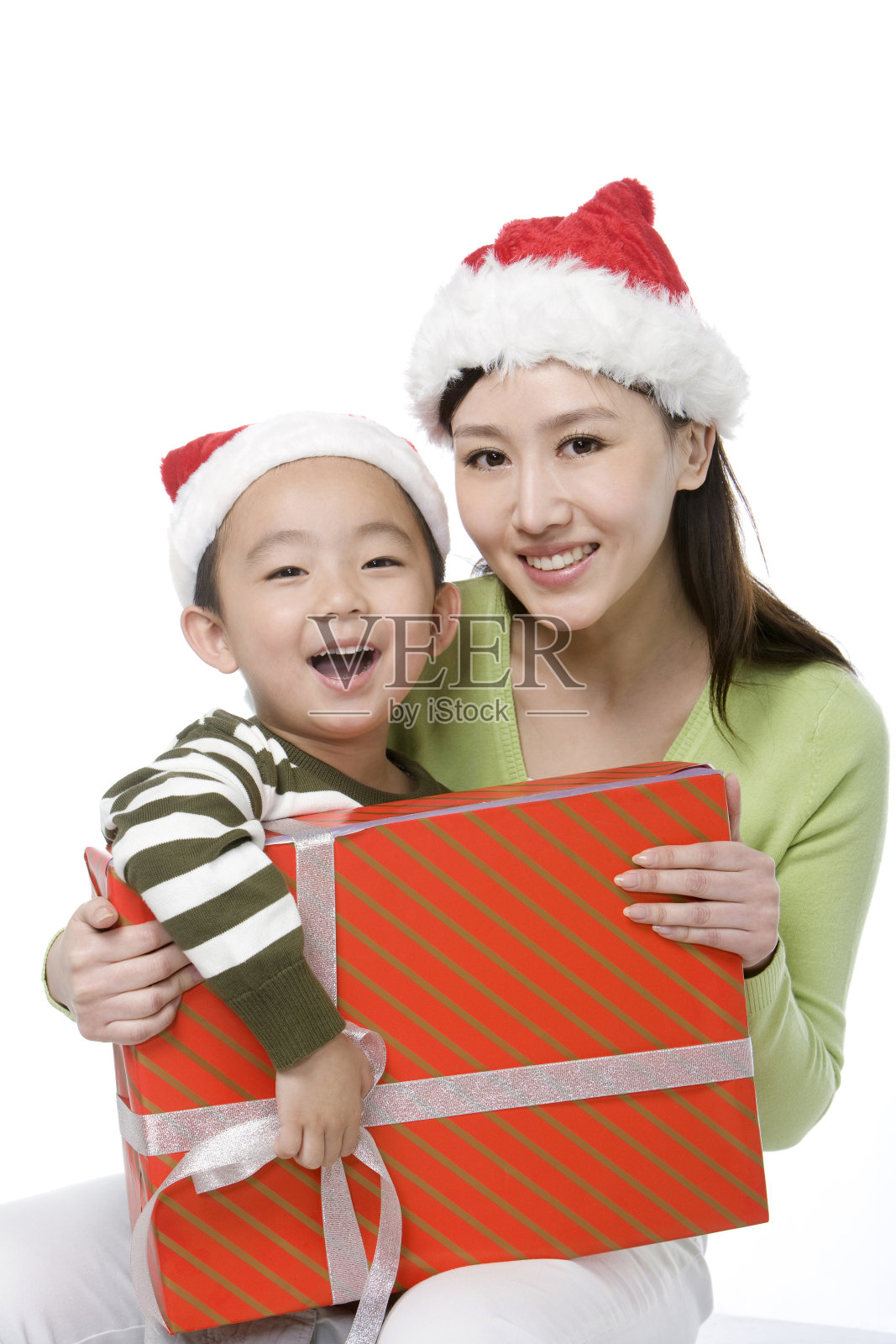 戴着圣诞帽的母子抱着礼物照片摄影图片