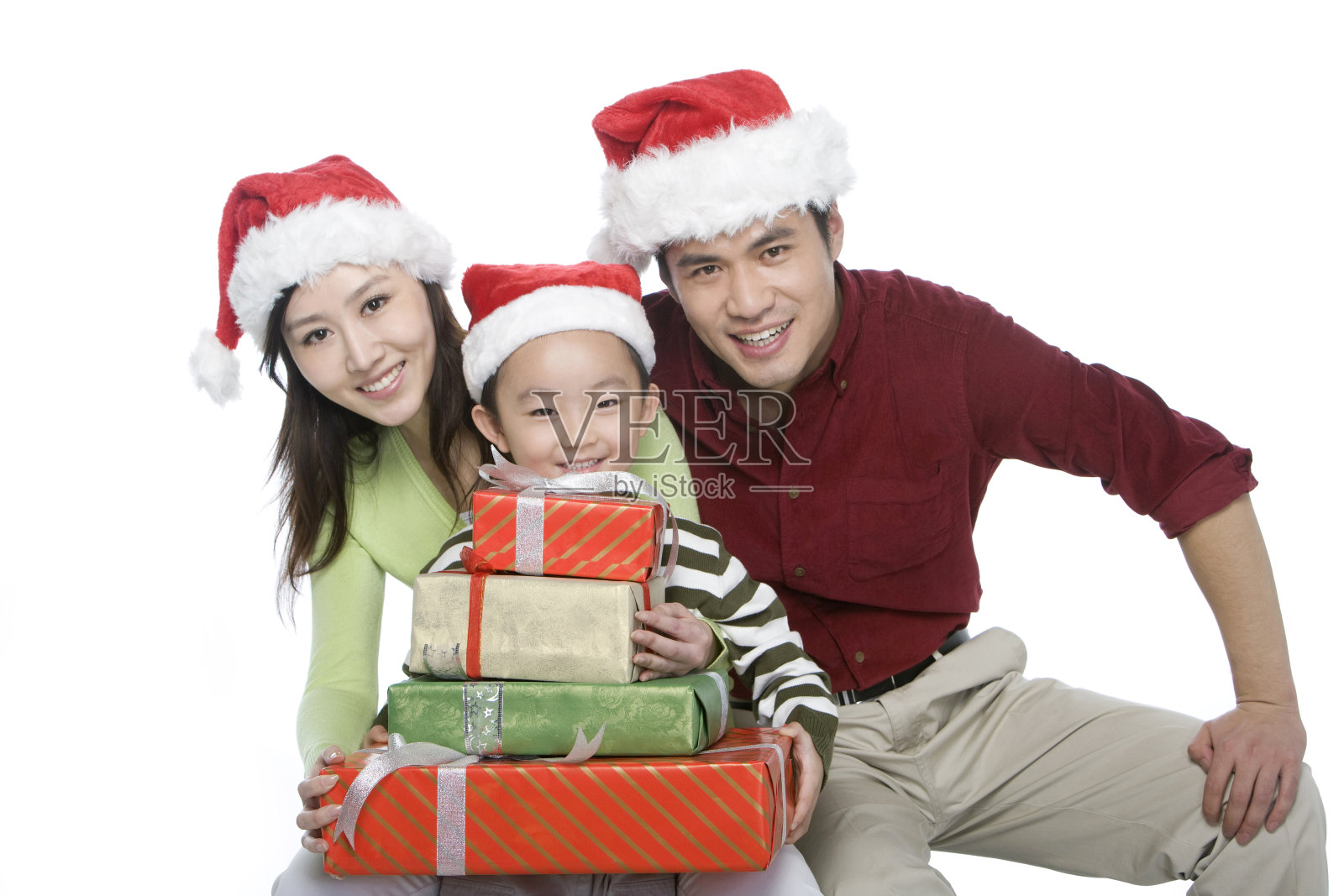 戴着圣诞帽的一家三口抱着礼物照片摄影图片
