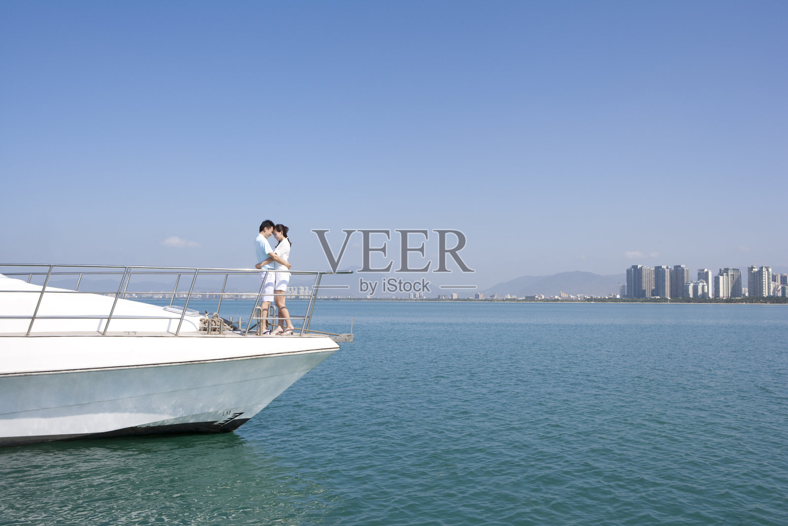 青年夫妇在游艇上拥抱照片摄影图片