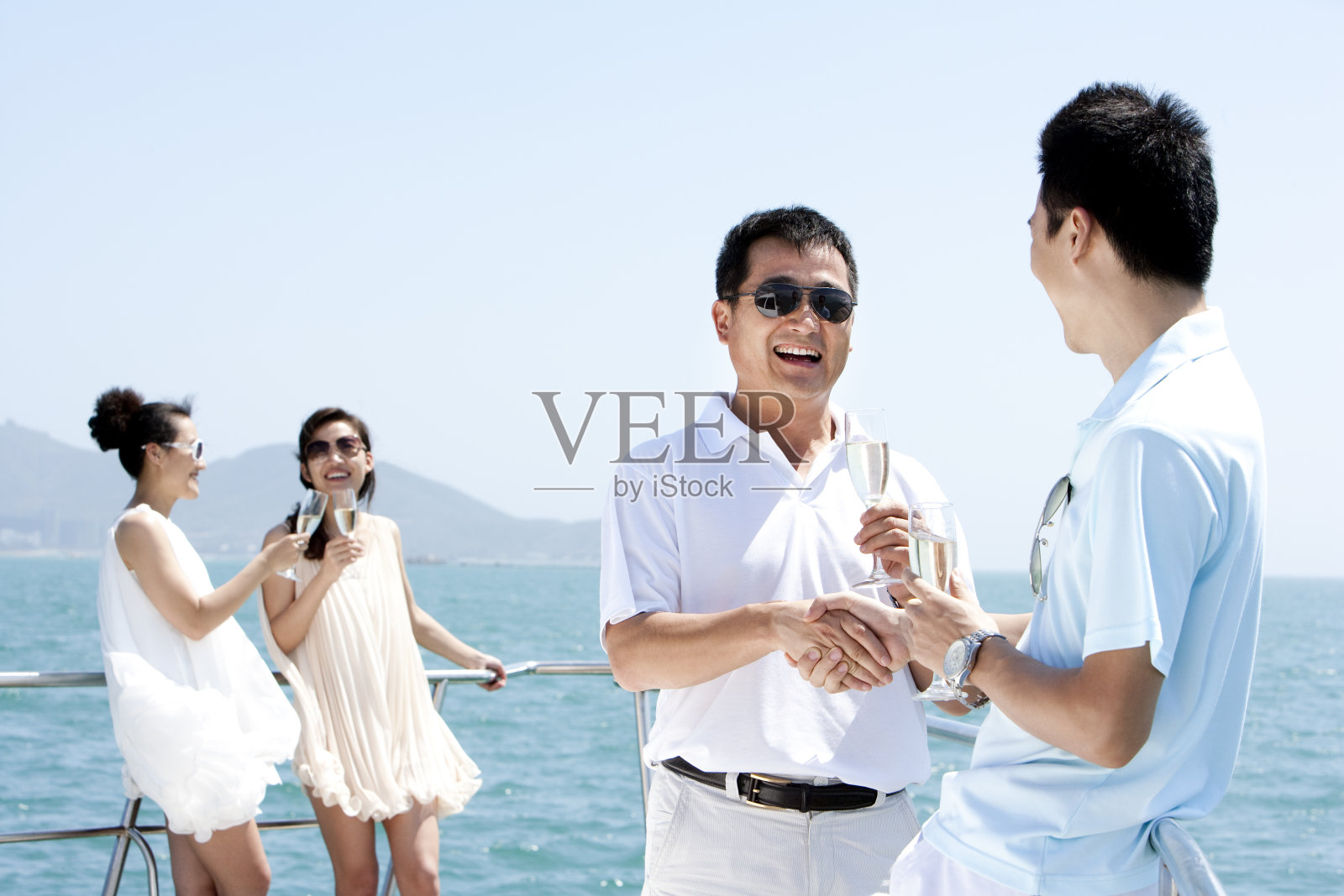 成功人士在游艇上喝香槟照片摄影图片